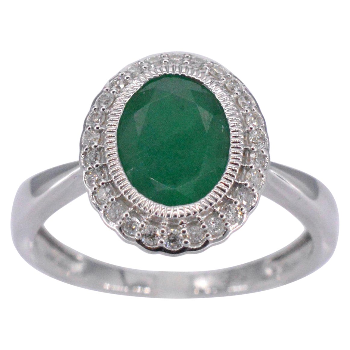 Bague entourage en or blanc avec diamants et émeraudes