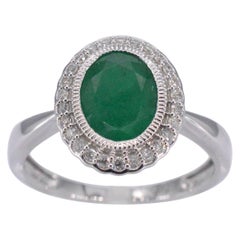 Bague entourage en or blanc avec diamants et émeraudes