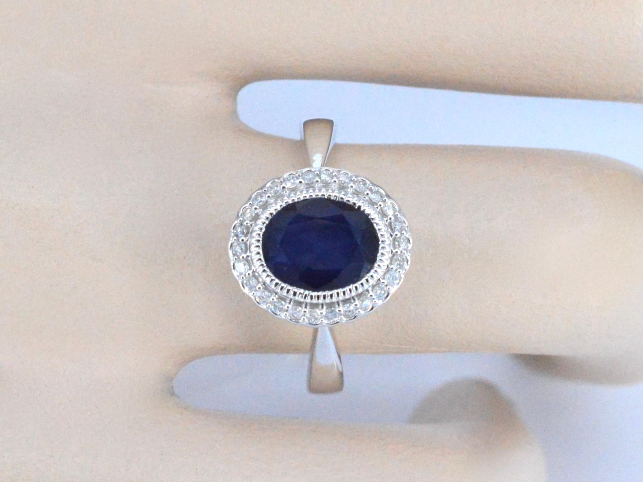 Introducing our stunning white gold entourage ring with diamonds and sapphire. This exquisite ring features a vibrant 3.00 carat oval cut sapphire, surrounded by 0.15 carats of brilliant cut diamonds. Crafted from 14 karat white gold and weighing