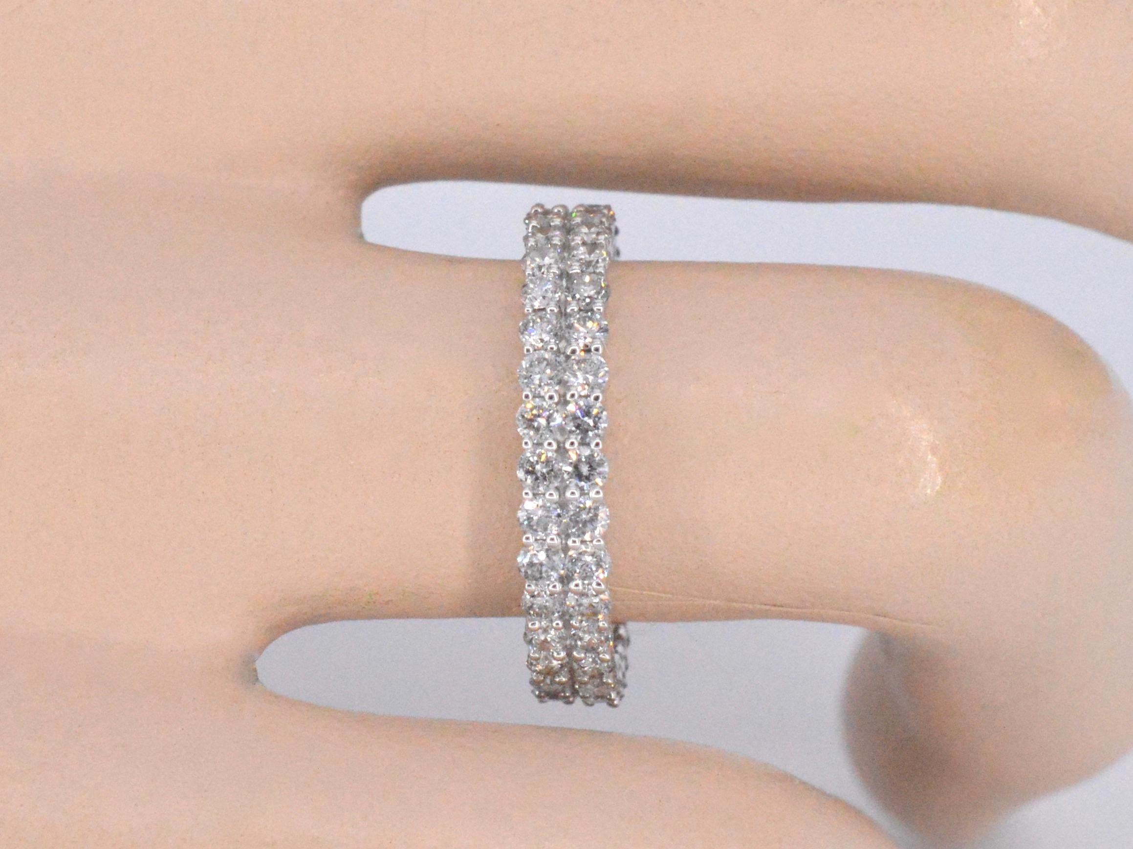A white golden double eternity ring with diamonds is a stunning piece of jewelry that features two bands of yellow gold, each adorned with diamonds that encircle the entire band. The diamonds are typically matched in size and quality to create a