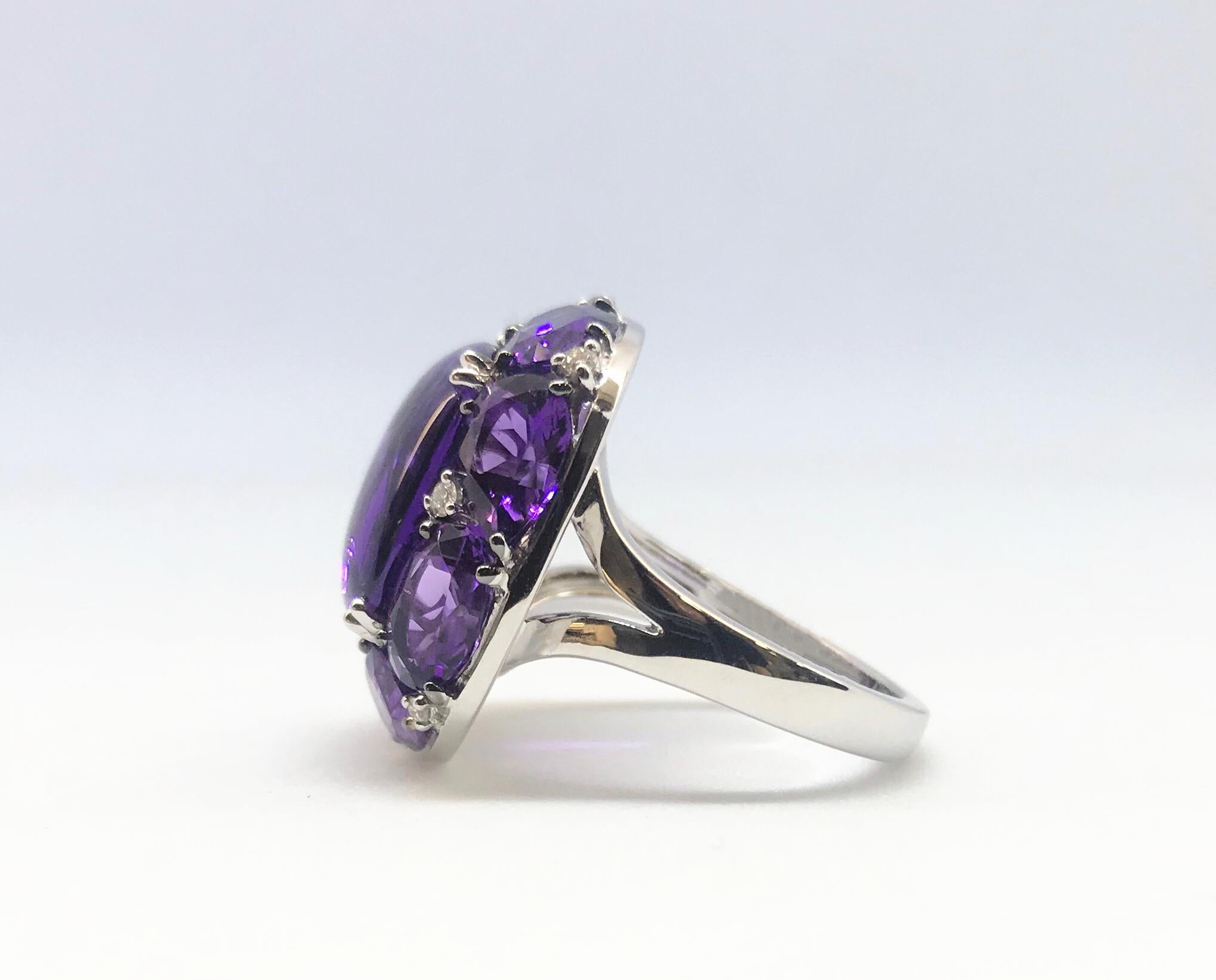 One 18 Karat white gold faceted and cabochon-cut multi-gem amethyst and diamond ring. The cushion-shaped ring centers one cushion-shaped cabochon-cut amethyst, held by 4-double prongs, and surrounded by an alternating pattern of 4-pear-shaped and 4-