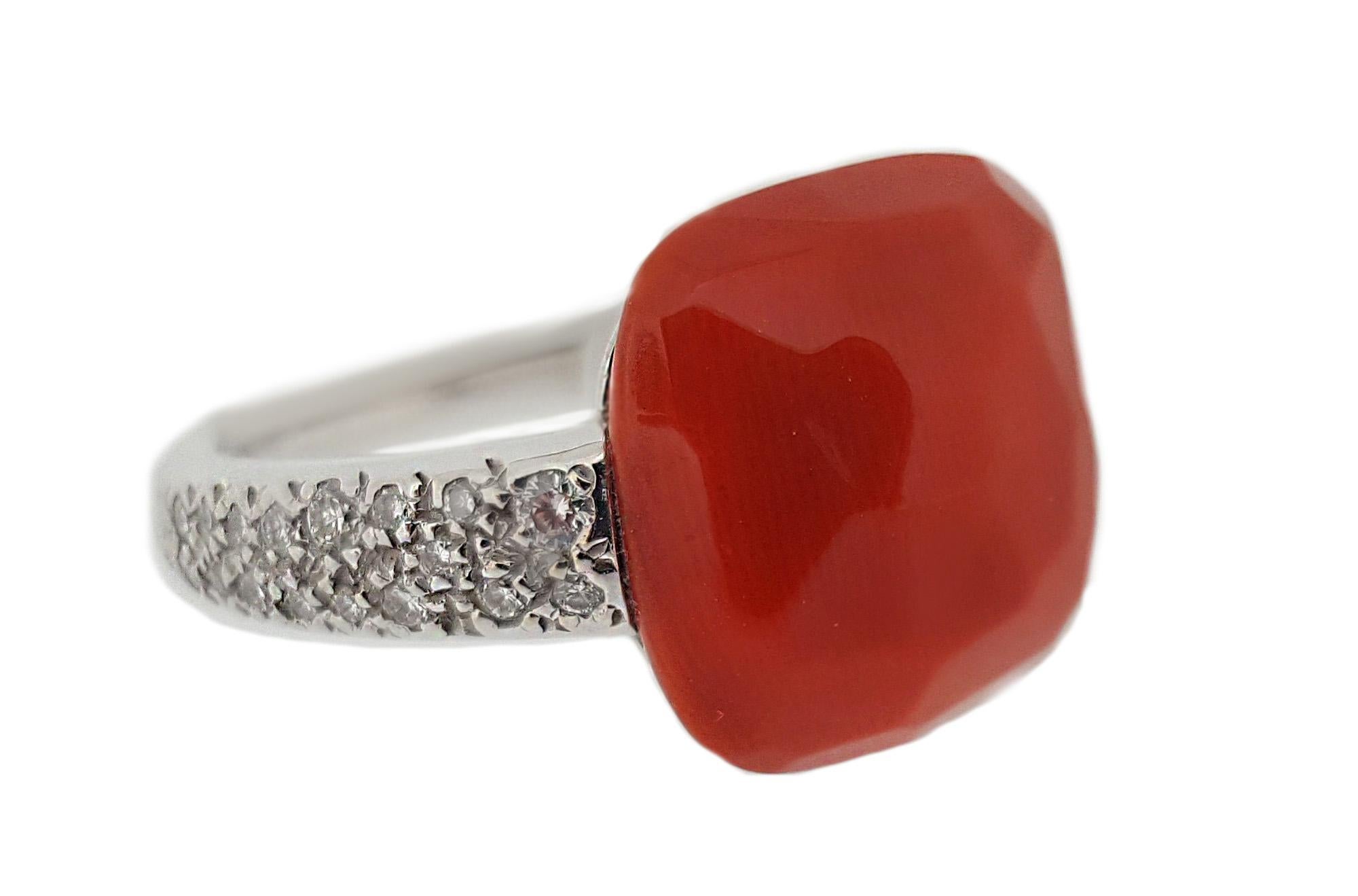This modern and elegant designer ring by Pomellato  features a vivid salmon colored, faceted, cushion shaped coral.  Also contains .17ctw of full cut round brilliant diamonds along the shank of this high polished 18kt white gold mounting.