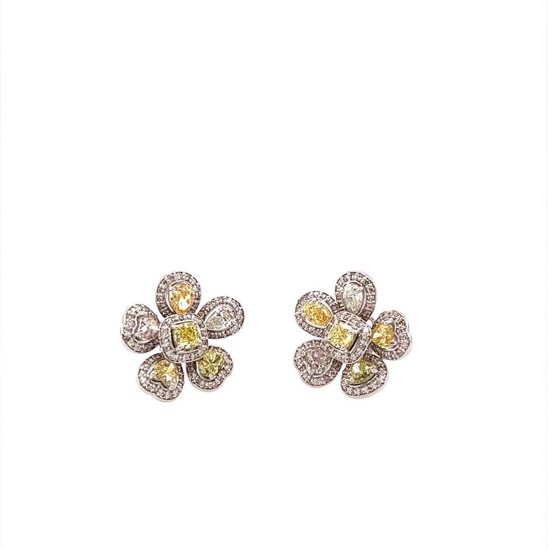 Clous d'oreilles floraux en diamant de couleur fantaisie et de forme mixte, réalisés à la main en or blanc, d'un poids total de 4,83 carats.  Chaque pierre de forme fantaisie est rehaussée d'un pavage de diamants blancs ronds et brillants. Le pavé