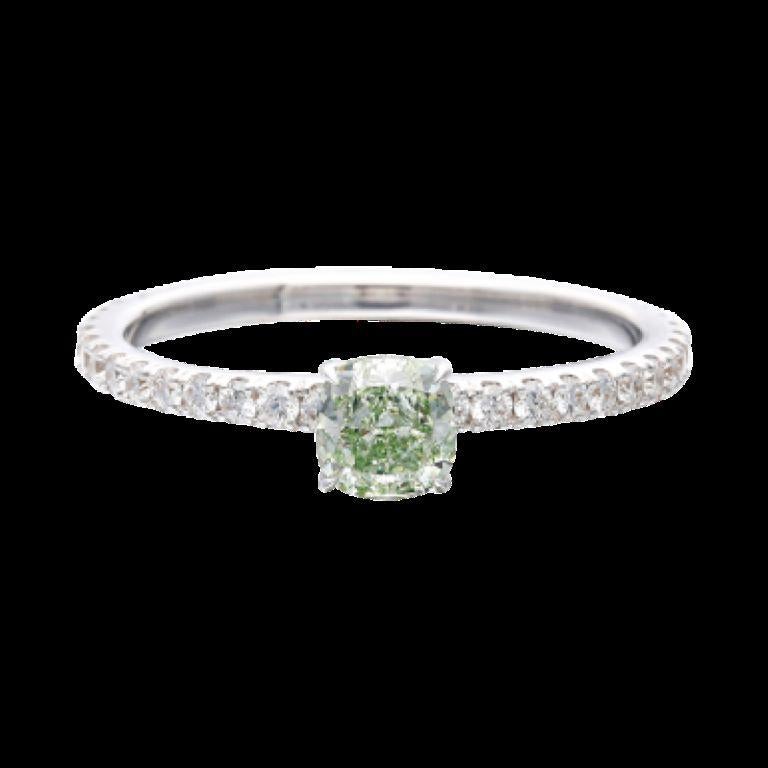 Centering a green diamond, accented by round brilliant cut diamonds. 
- Green diamond weighs 0.41 carat 
- Round brilliant cut diamonds weighing a total of approximately 0.30 carat
- Size 6 1/2 - Total weight 1.85 grams - 18 karat white gold 
-