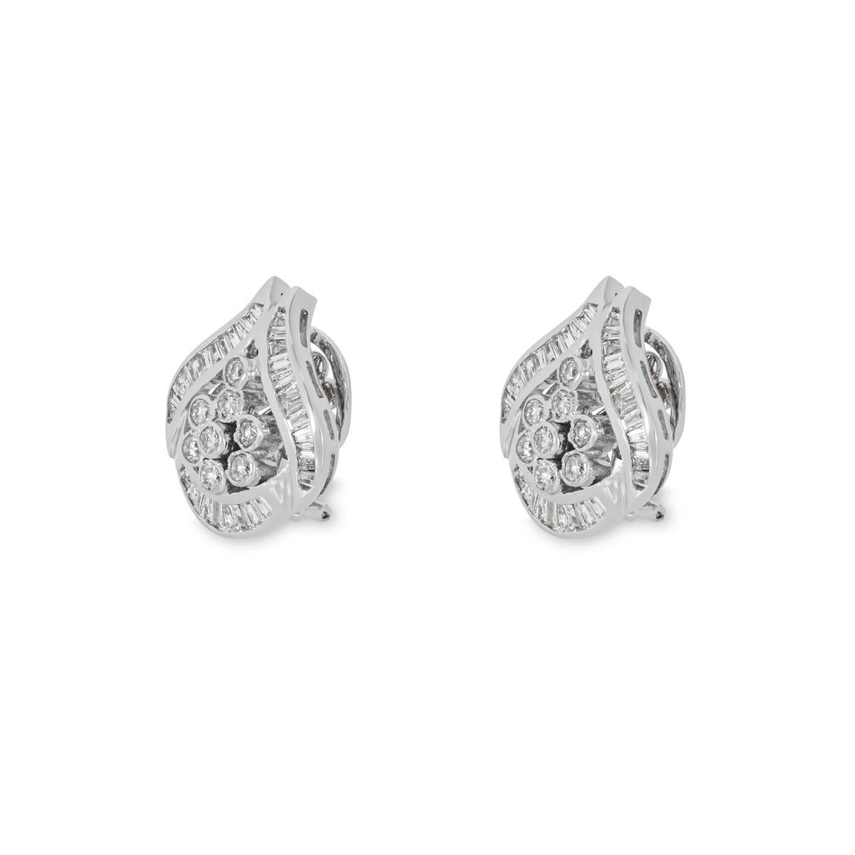 A sparkly pair of 18k white diamond earrings. The earrings each feature a floral motif set to the centre consisting of 8 round brilliant cut diamonds with an approximate total weight of 0.64ct G-H colour and SI clarity. Set around the border in a