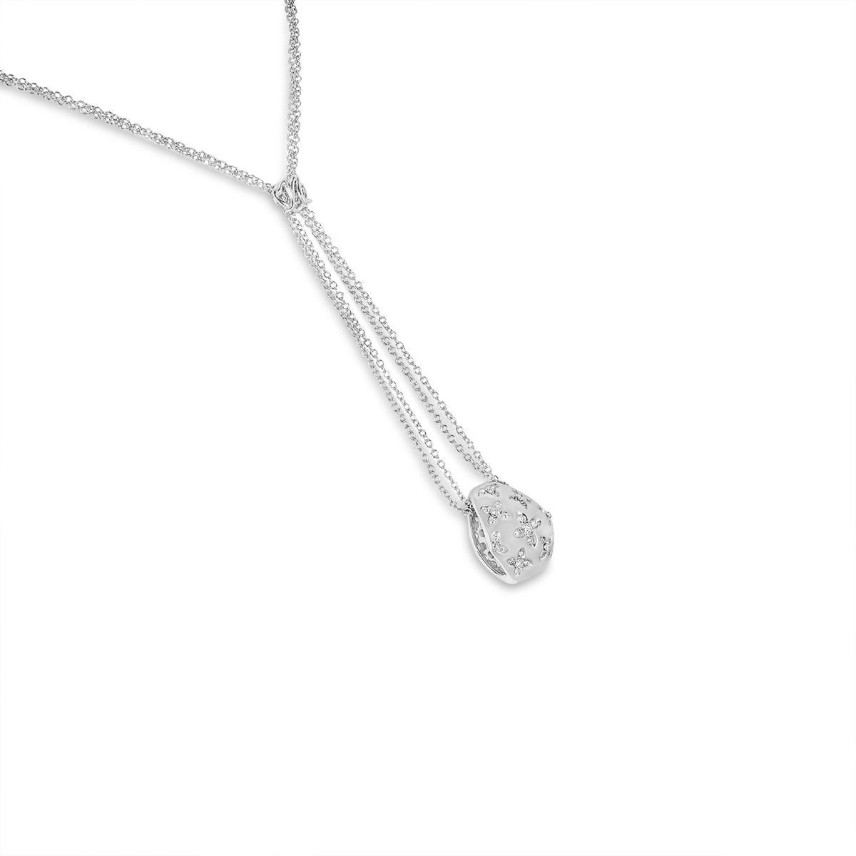 A lovely 18k white gold diamond pendant. The necklace consists of a cursive style letter 'N' set above a floral pattern diamond set pendant. The 35 round brilliant cut diamonds have an approximate total weight of 0.72ct, G-H colour and VS-SI