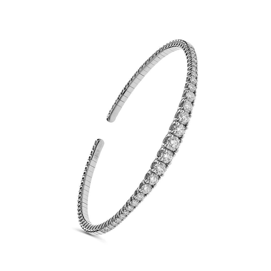 Indulge in the timeless allure of this white Gold Diamond Flexible Cuff adorned with exquisite round-cut diamonds. Crafted from 18-karat white gold and encrusted with glistening diamonds, this cuff is flexible and able to fit many wrist sizes. The