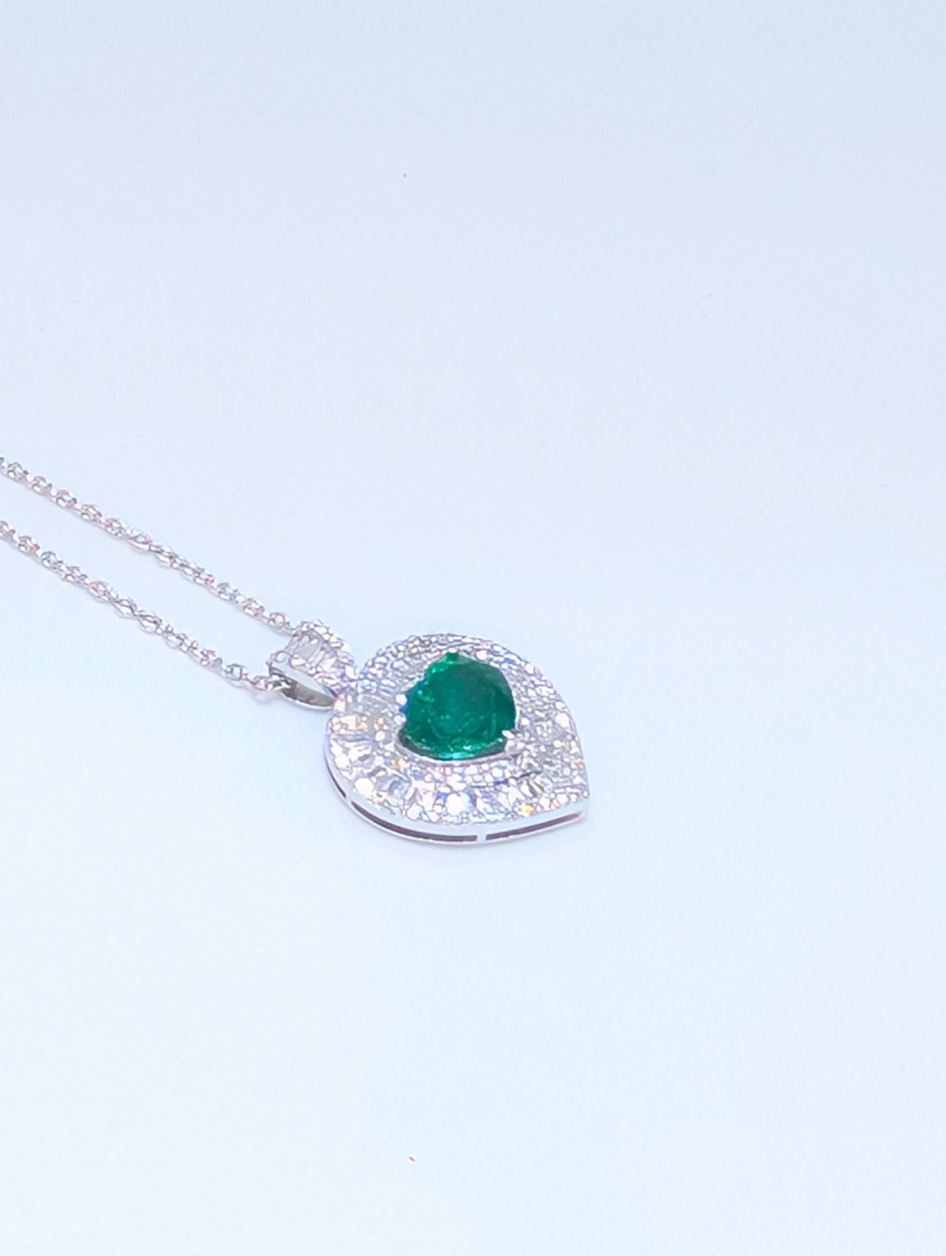 Este exquisito collar ajustable de 16 pulgadas está elaborado en luminoso oro blanco de 18 quilates y presenta un cautivador colgante en forma de corazón suspendido graciosamente de la cadena. En su centro, una vívida esmeralda verde talla corazón