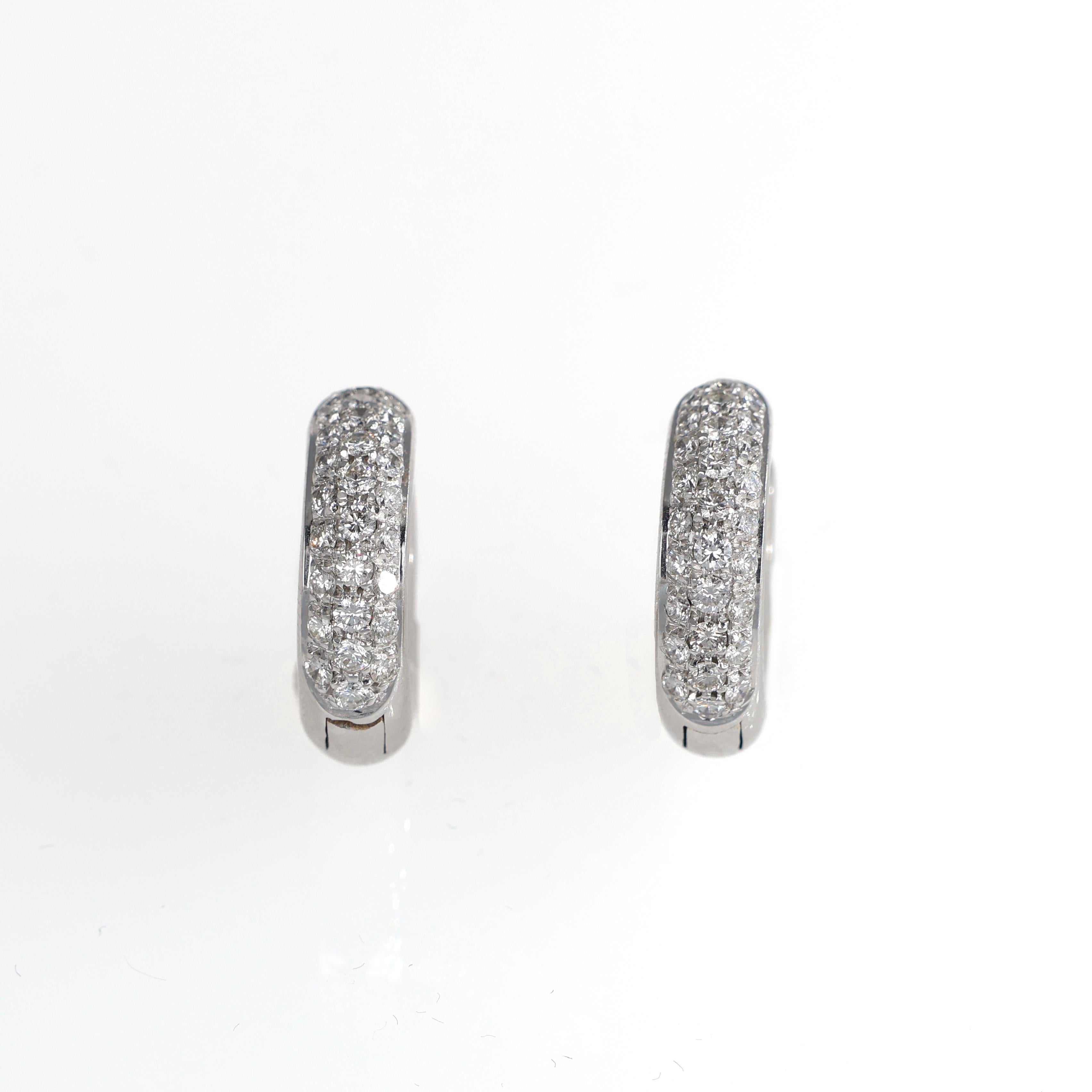A timeless pair of hoop earrings crafted in 18K white gold, featuring a refined pavé of brilliant-cut diamonds. The sparkling stones, totaling 0.70 carats, elegantly enhance the sleek curvature of the hoops, adding a touch of understated luxury.