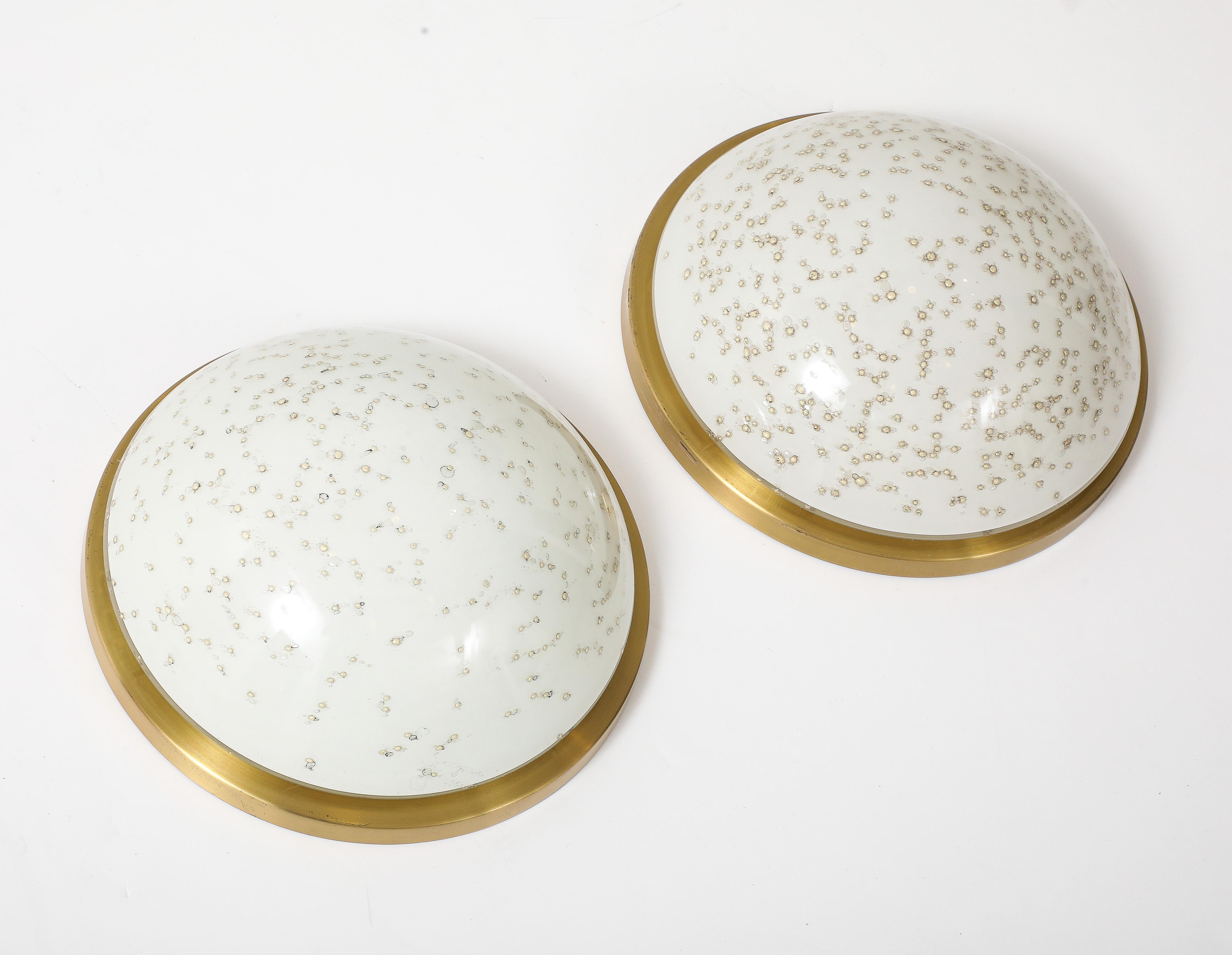 Coppia di appliques dimensionali in vetro di Murano bianco con inclusioni dorate. Il vetro è montato su piastre di ottone. Ricablato professionalmente per l'uso negli Stati Uniti. 
