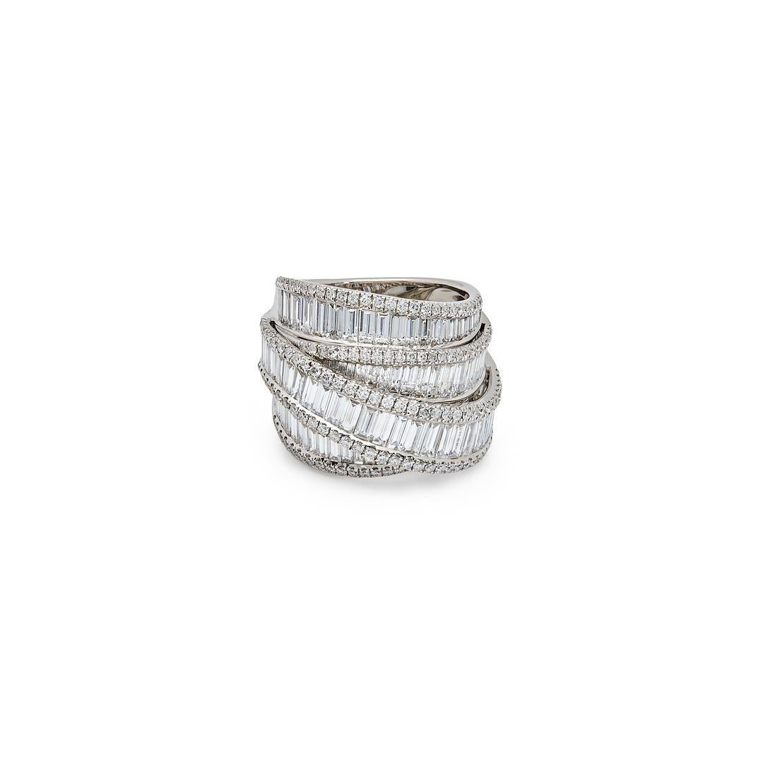 Indulge in the opulent elegance of our White Gold Invisible Set Baguette Layered Cocktail Ring.
Crafted from 18-karat white gold, this ring features multiple layers of shimmering round and channel-set baguette-cut diamonds. The intricate