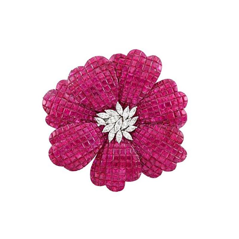 A White Gold, Invisibly-Set Ruby and Diamond Flower Brooch
18 kt., the petals of square, ruby and fancy-shaped rubies approximately 73.48 cts., centering a cluster of 15 marquise-shaped diamonds approximately 1.46 cts., approximately 22.3 dwts. 