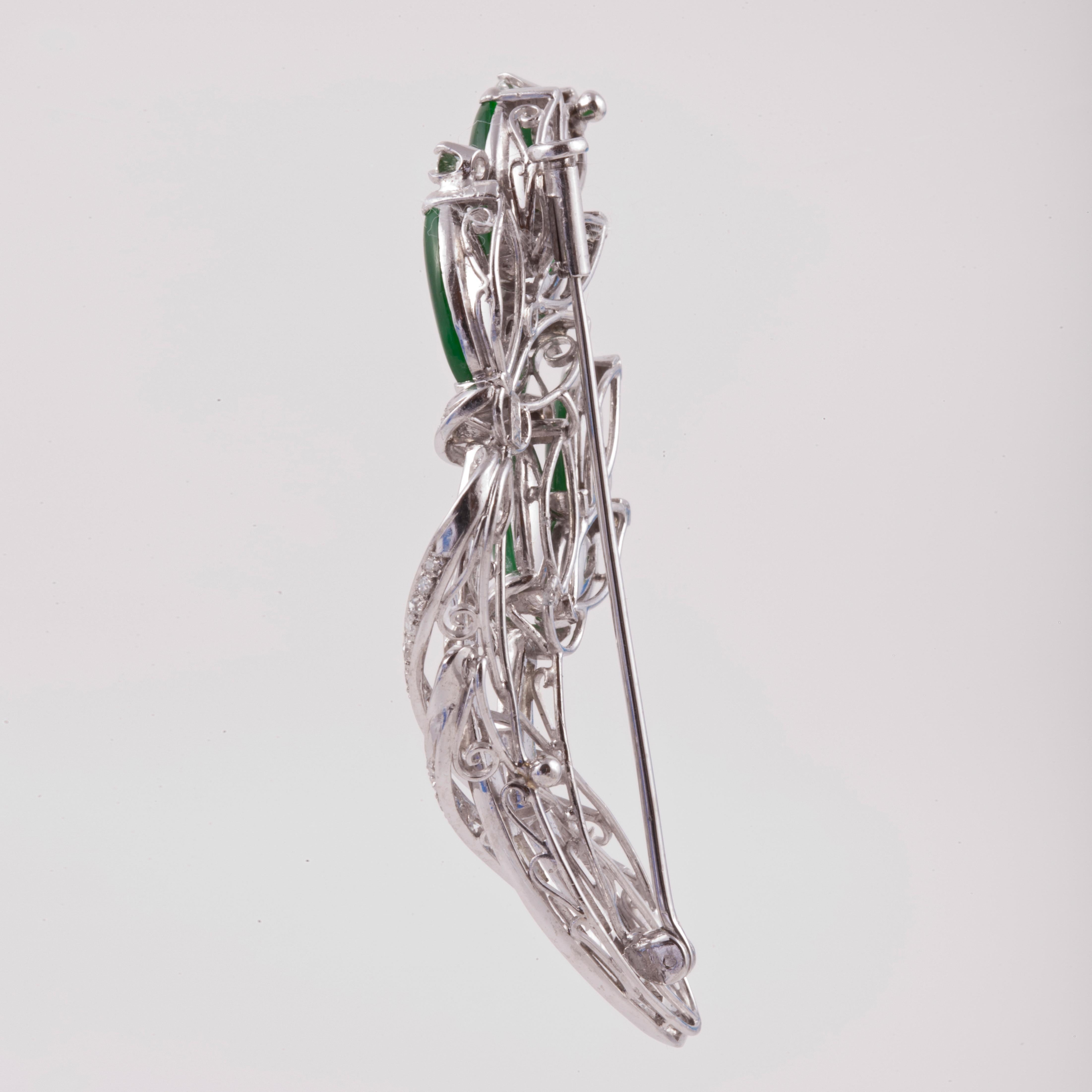 14K white gold pin set with eight marquise-shaped jade stones.  There are also 56 round diamonds and 12 baguette diamonds with a total carat weight of 1.35; G-J color and VS-SI clarity.  Pin measures 2 3/16 inches by 1 inch and has a trombone