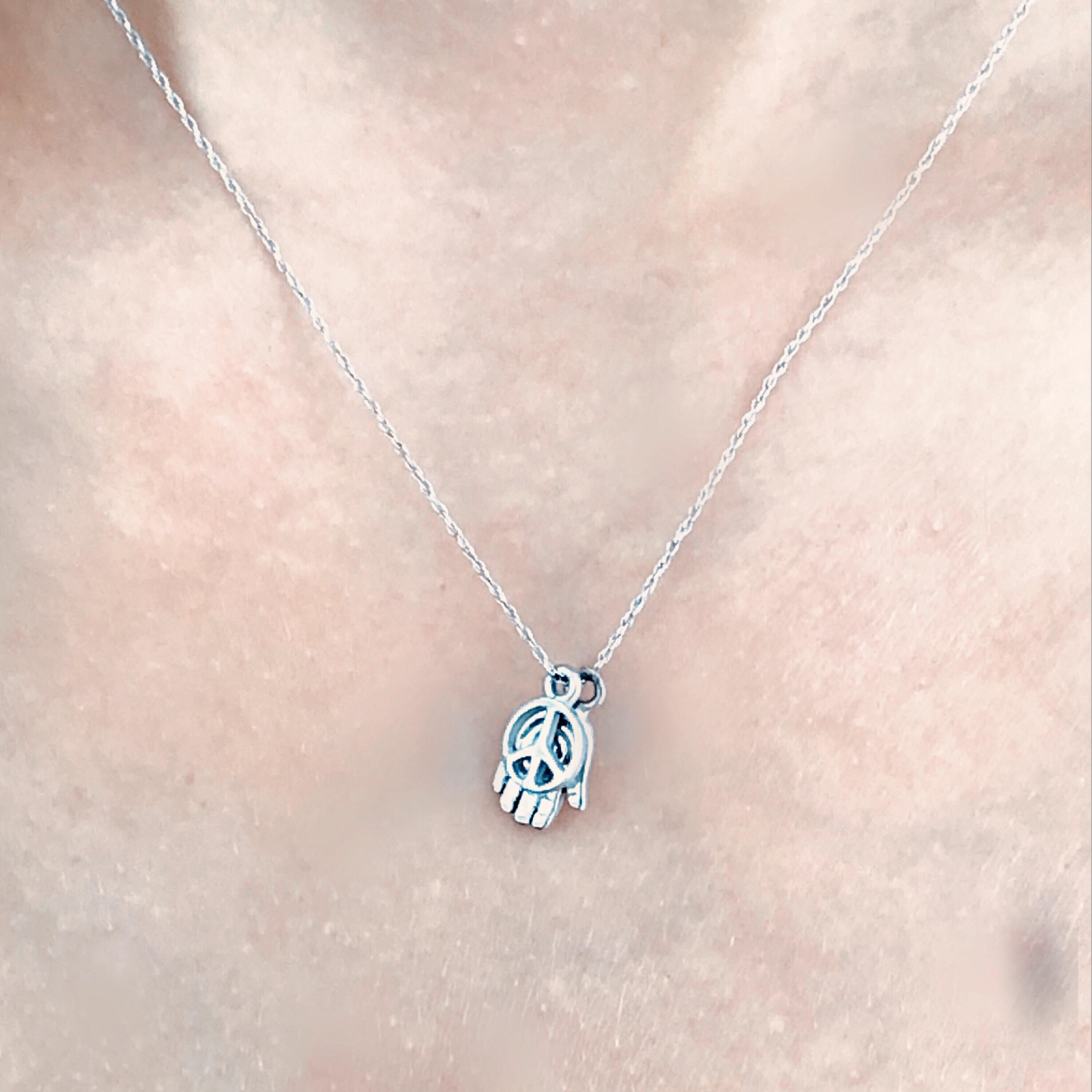 14 karat white gold necklace pendant with two charms 
Hand hamsa and peace sign charms
Chain 18
