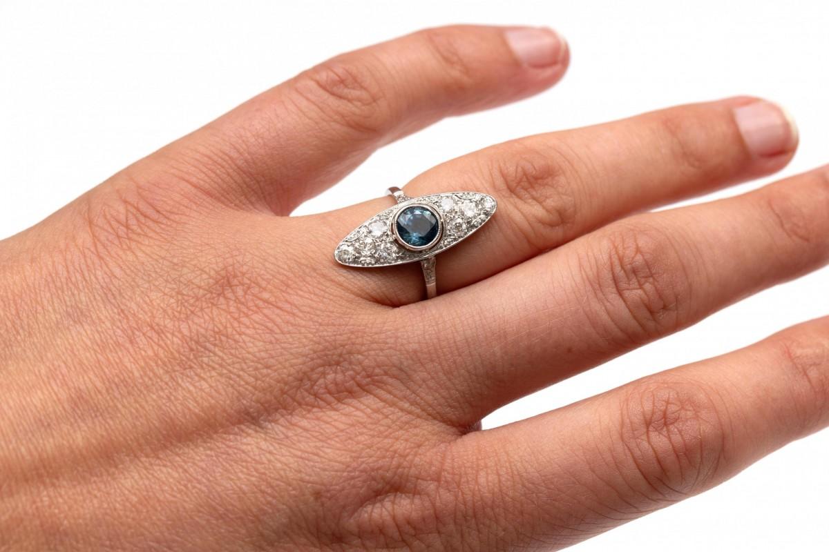 Un anello vintage unico nel suo genere: un marquise Art Deco con zaffiro e diamanti.

Realizzato in oro bianco 18 carati con elementi in platino.

Origine: Europa occidentale, anni '30/'40.

Al centro è incastonato uno zaffiro rotondo del peso di