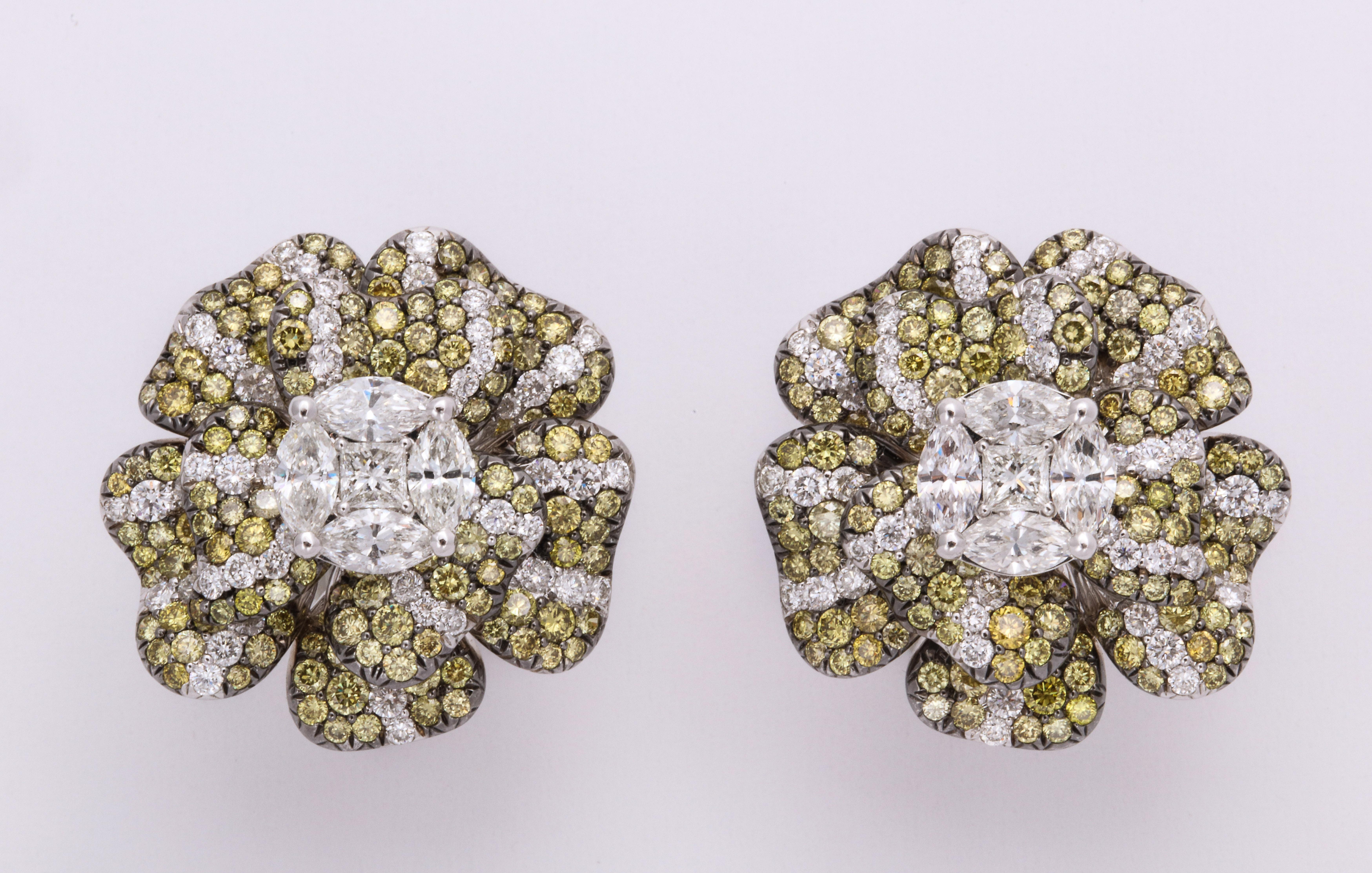 Bright and happy 18K white gold floral earclips composed of individual petals adding animated breath to the complete flower.  Completely pave'-set with natural color round brilliant cut greenish yellow diamonds, and wisps of colorless diamonds,