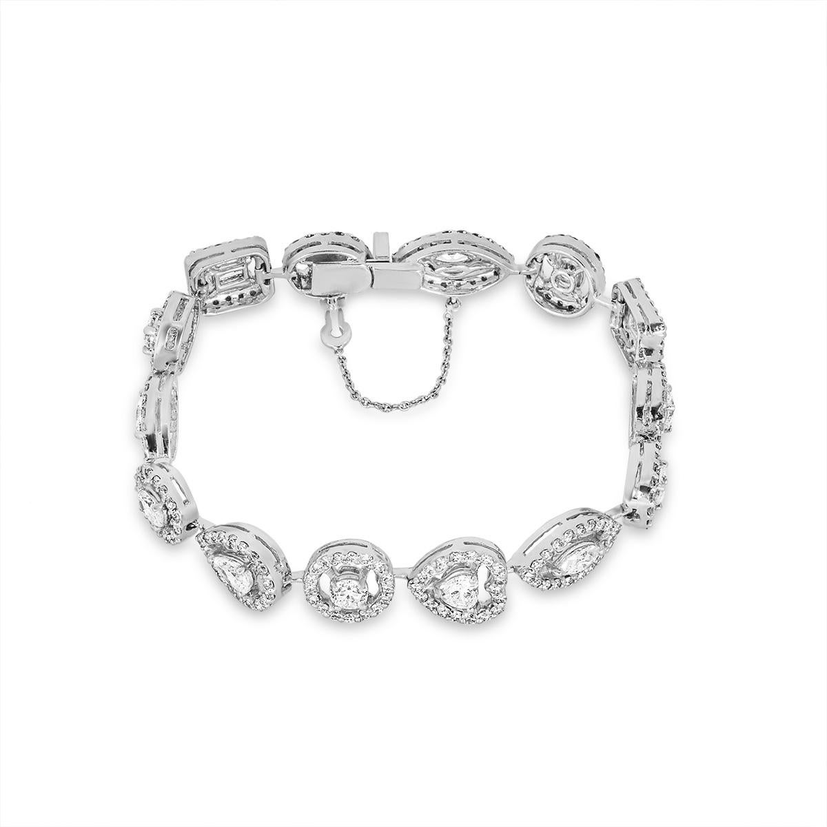 A stunning 18k white gold diamond halo bracelet. The bracelet features 14 diamond stations comprising of: 3 oval cut diamonds, 2 emerald cut diamonds, 3 round brilliant cut diamonds, 3 marquise cut diamonds, 2 pear cut diamonds, 1 heart shaped