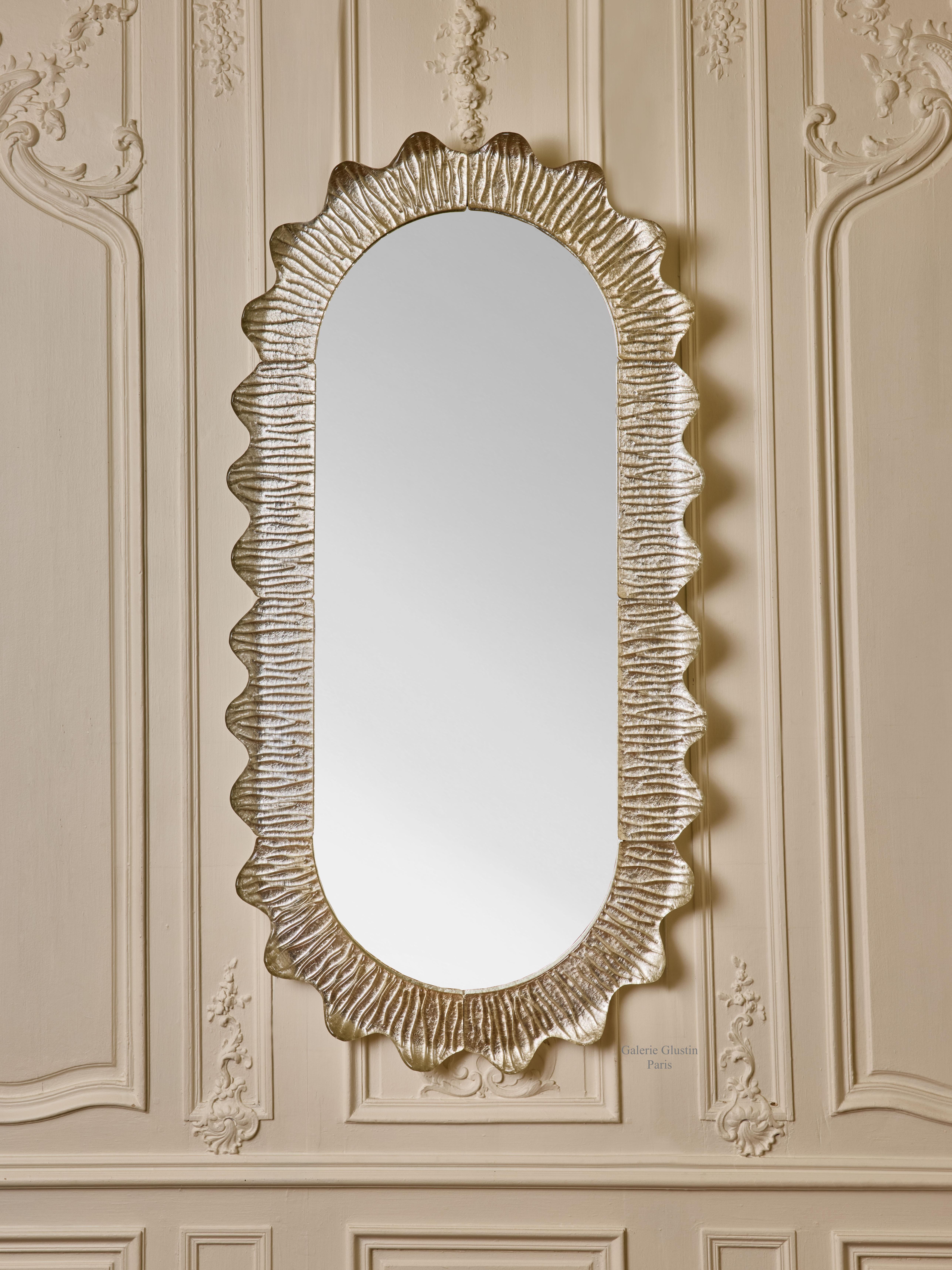 Oval mirror with frame in sculpted Murano glass, gilt with white gold leaf.
Italy, 2024.