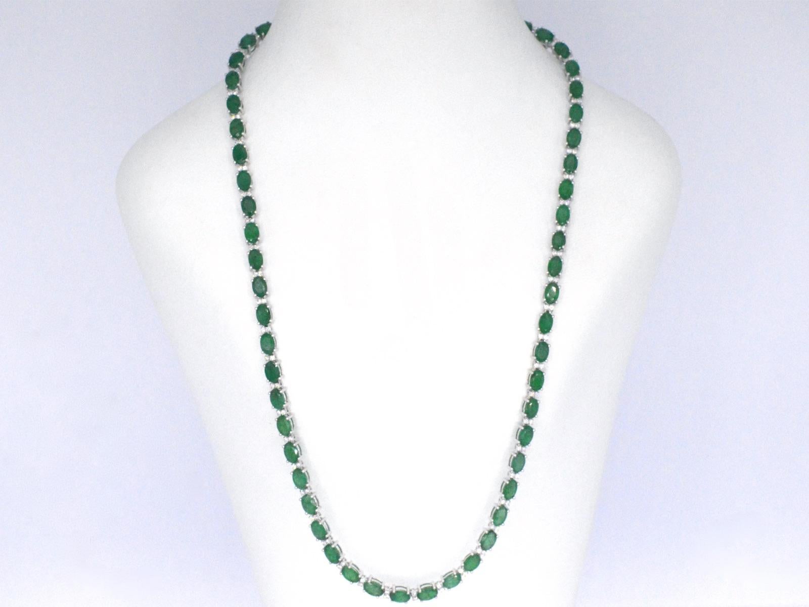 This white gold necklace is an exquisite piece of jewelry that features 25.00 carats of oval-cut emeralds and sparkling diamonds. The emeralds are arranged in a breathtaking pattern that creates a stunning display of color and brilliance, while the