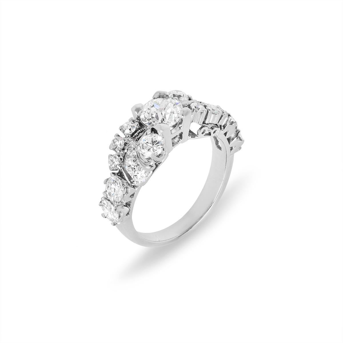 A unique 14k white gold diamond engagement ring. The ring is set to the centre with an Old European cut diamond weighing approximately 0.86ct, H colour and VS clarity. Further complementing the centre diamond are 6 round brilliant cut diamonds and