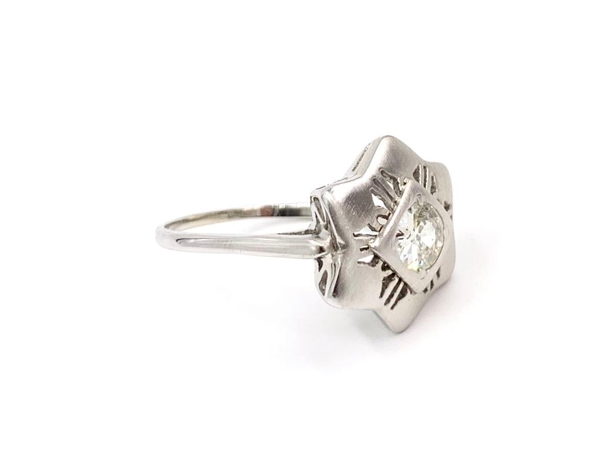 Circa 1930's, a simply beautiful satin finished 14 karat white gold star motif ring featuring a single old mine cut diamond at approximately .90 carats. Diamond quality is approximately L color, SI2 clarity. Ring has been re-shanked with a 1.5mm
