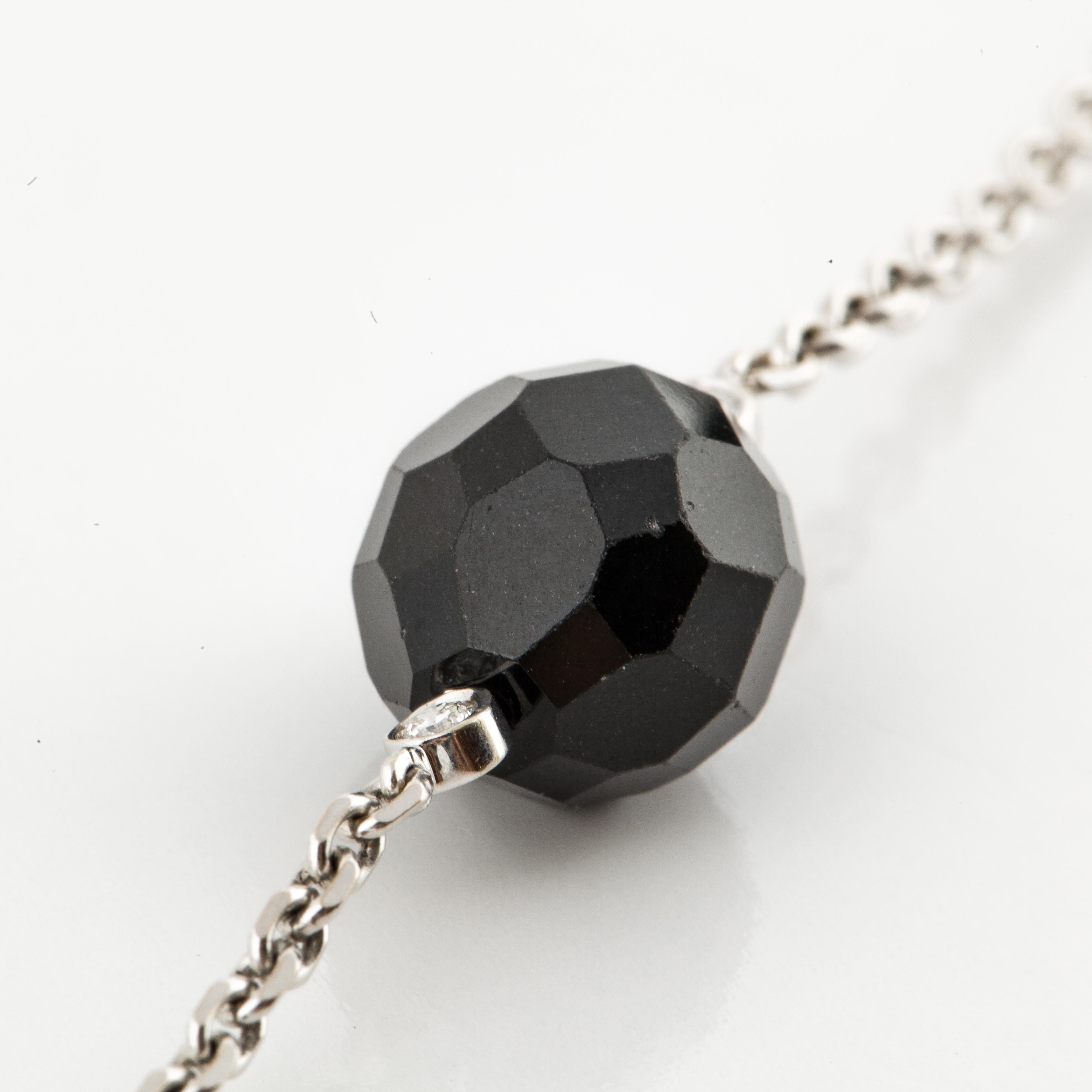 18K white gold chain necklace in a bead by the yard style, interspersed with faceted onyx beads and bezel set diamonds.  Measures 33 inches in length long and the beads are 7/16 inches across.