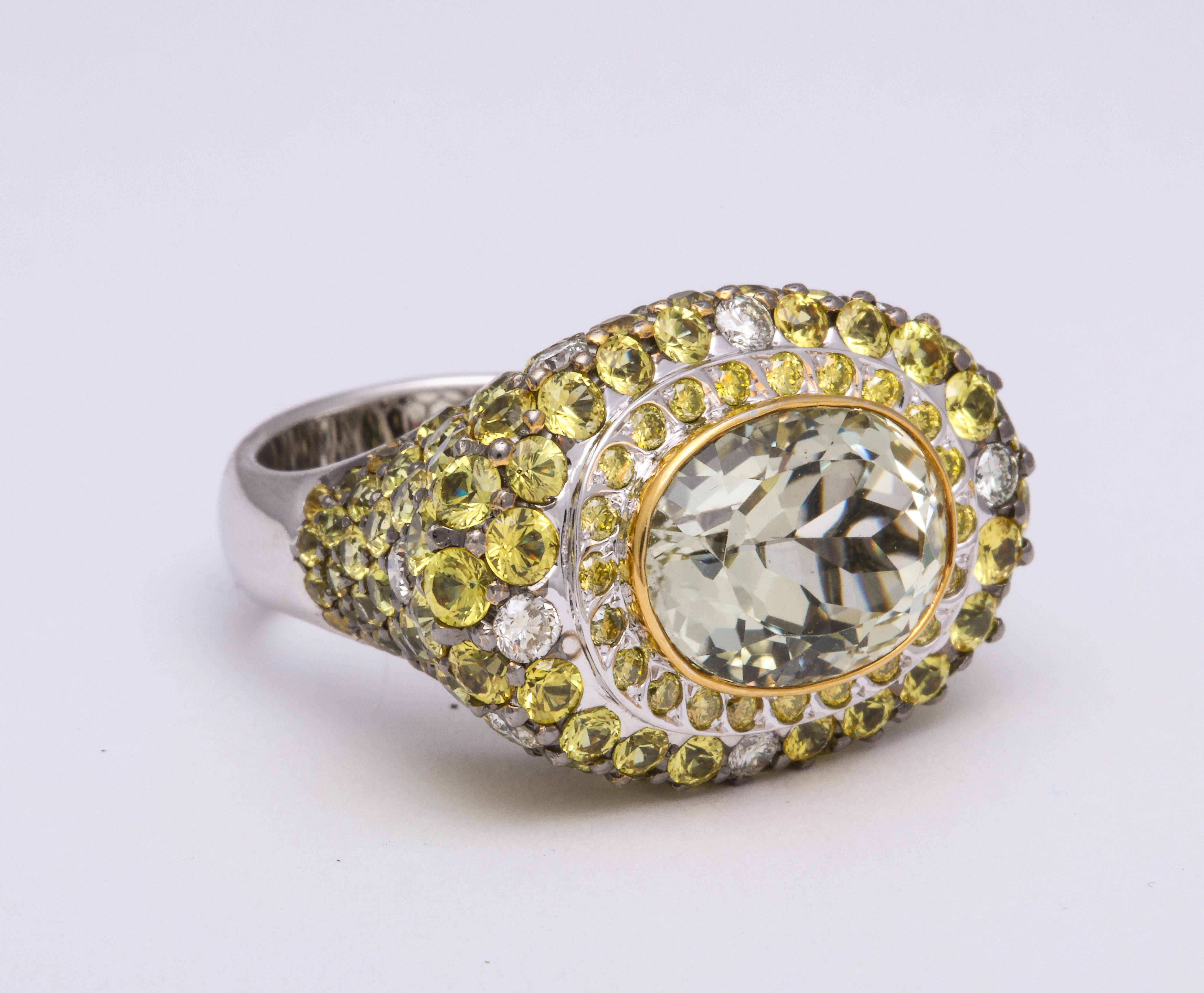 Contemporary and BOLD high and flat top 18 Karat white gold cocktail ring mounted with east:west orientation faceted oval yellow sapphire, bezel-set: 7.71 carats, decorated with round diamond-cut yellow sapphires: 5.79 carats, and staggered