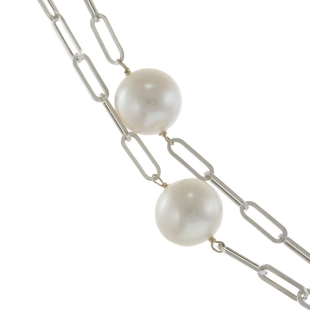 Ce collier, qui reprend avec raffinement le style classique des coupes en fer-blanc, est composé de perles lustrées de 10,5 à 11,5 mm disposées le long d'une chaîne à trombones en or blanc 14KT de 36 pouces. La longueur généreuse permet un style