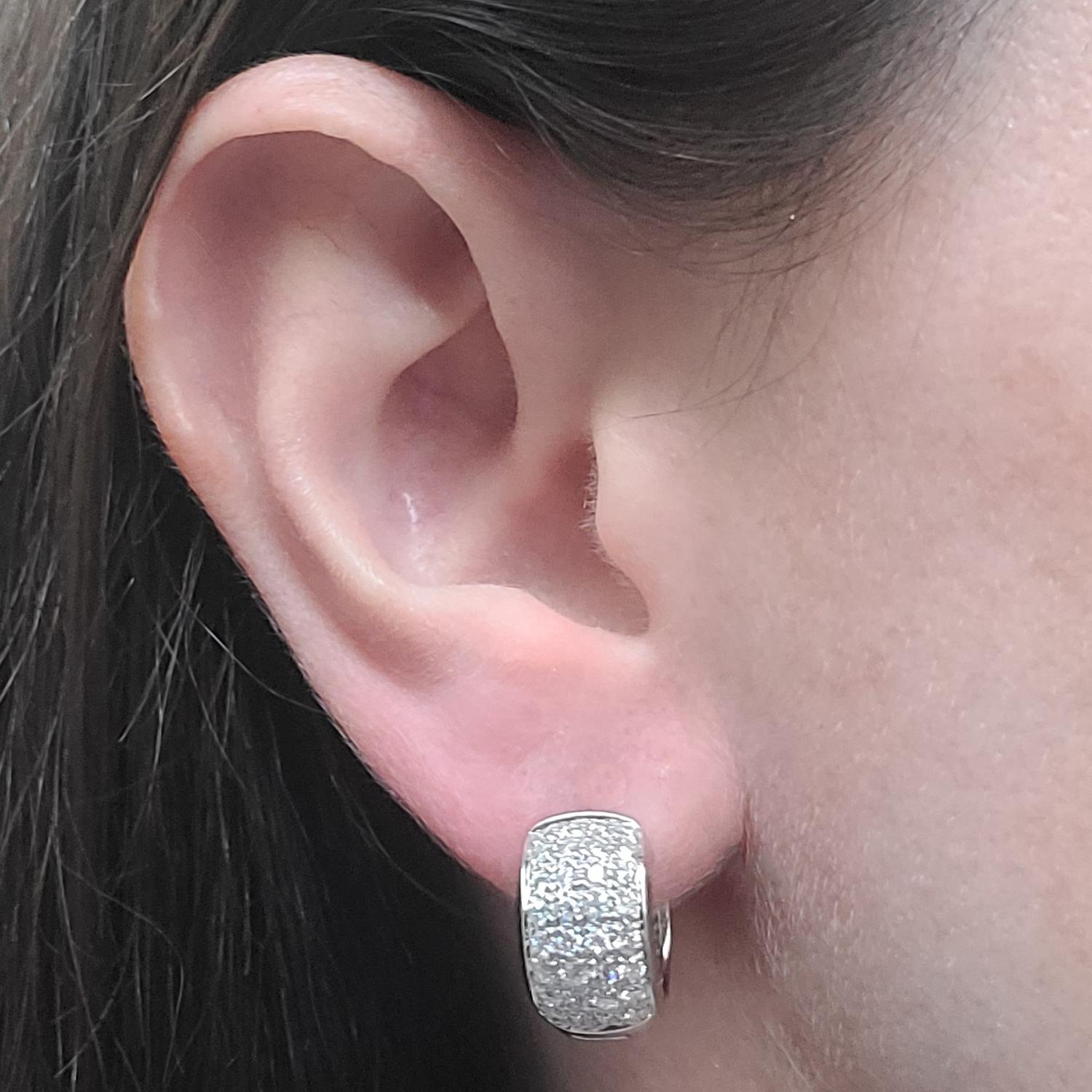 14 Karat White Gold Rounded Pave Huggie Hoop Earrings Featuring 64 Round Brilliant Cut Diamonds Of VS Clarity & G/H Color Totaling Approximately 1.00 Carat. Finished Weight Is 7.8 Grams. Post With Hinged Snap Back.