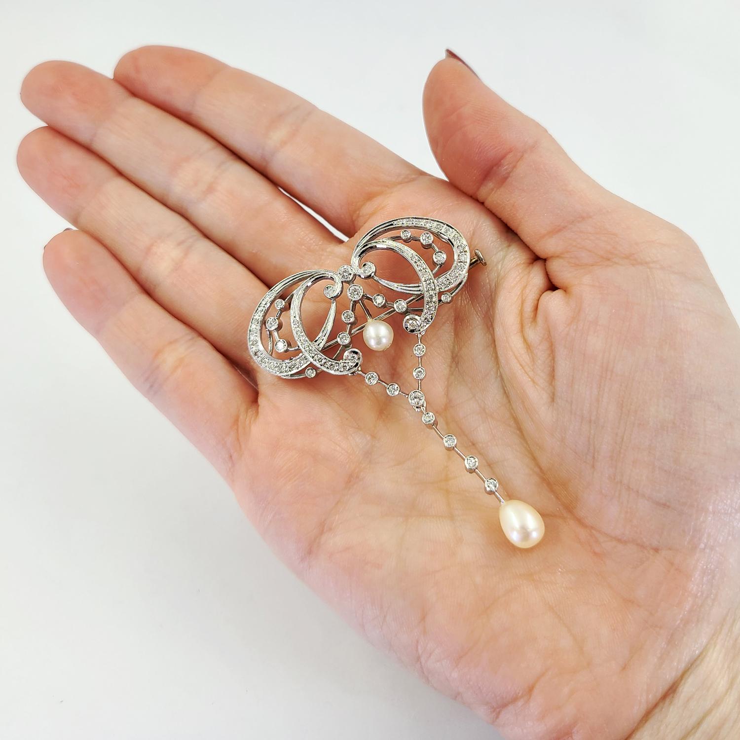 14 Karat White Gold Convertible Pin & Slide Pendant Featuring 63 Round Brilliant Cut Diamonds Of VS Clarity & G/H Color Totaling Approximately 1.00 Carat & 2 Cultured Drop Pearls. 2.5 Inch Length. Finished Weight Is 10.4 Grams. Antique Reproduction.