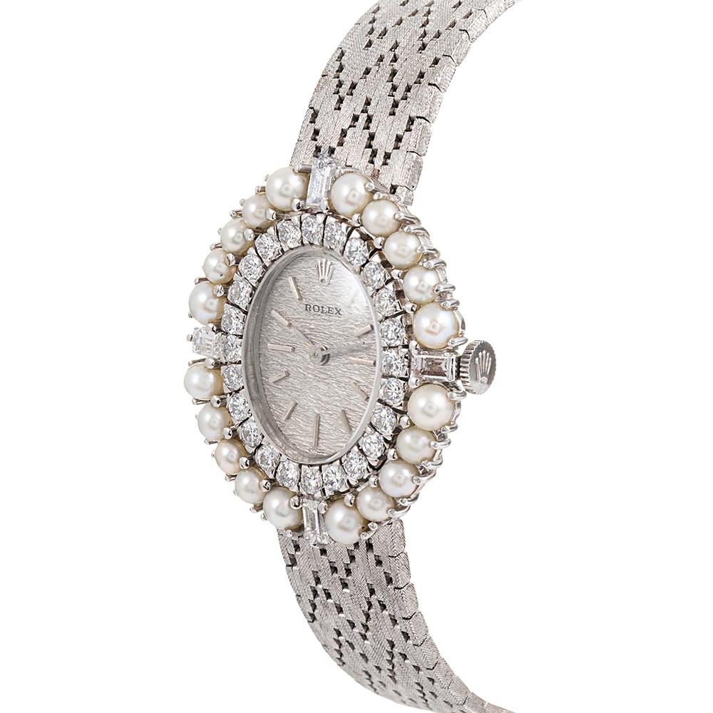 Pearl and diamond is a rarely seen combination for a vintage Rolex. This piece celebrates 1960s style in true grandeur, with the uniquely-textured bracelet emerging from beneath the oval bezel. Baguette diamonds mark the compass points while round