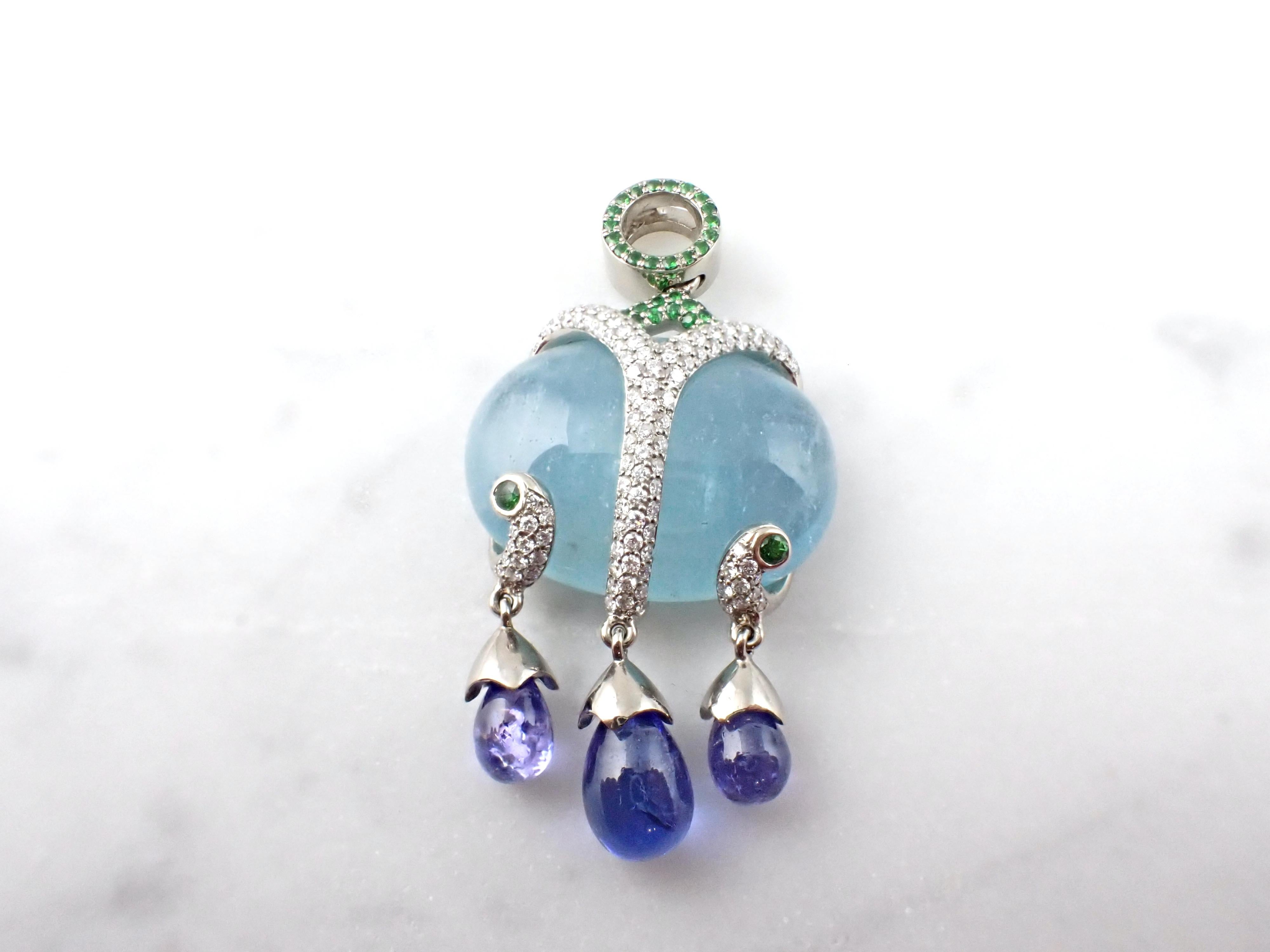 Indulge in the ocean's allure with our exquisite pendant, showcasing an oval cabochon aquamarine gemstone that echoes the sea's tranquility. Below, three cabochon drop tanzanites sway gracefully, infusing elegance and fluidity into the design.