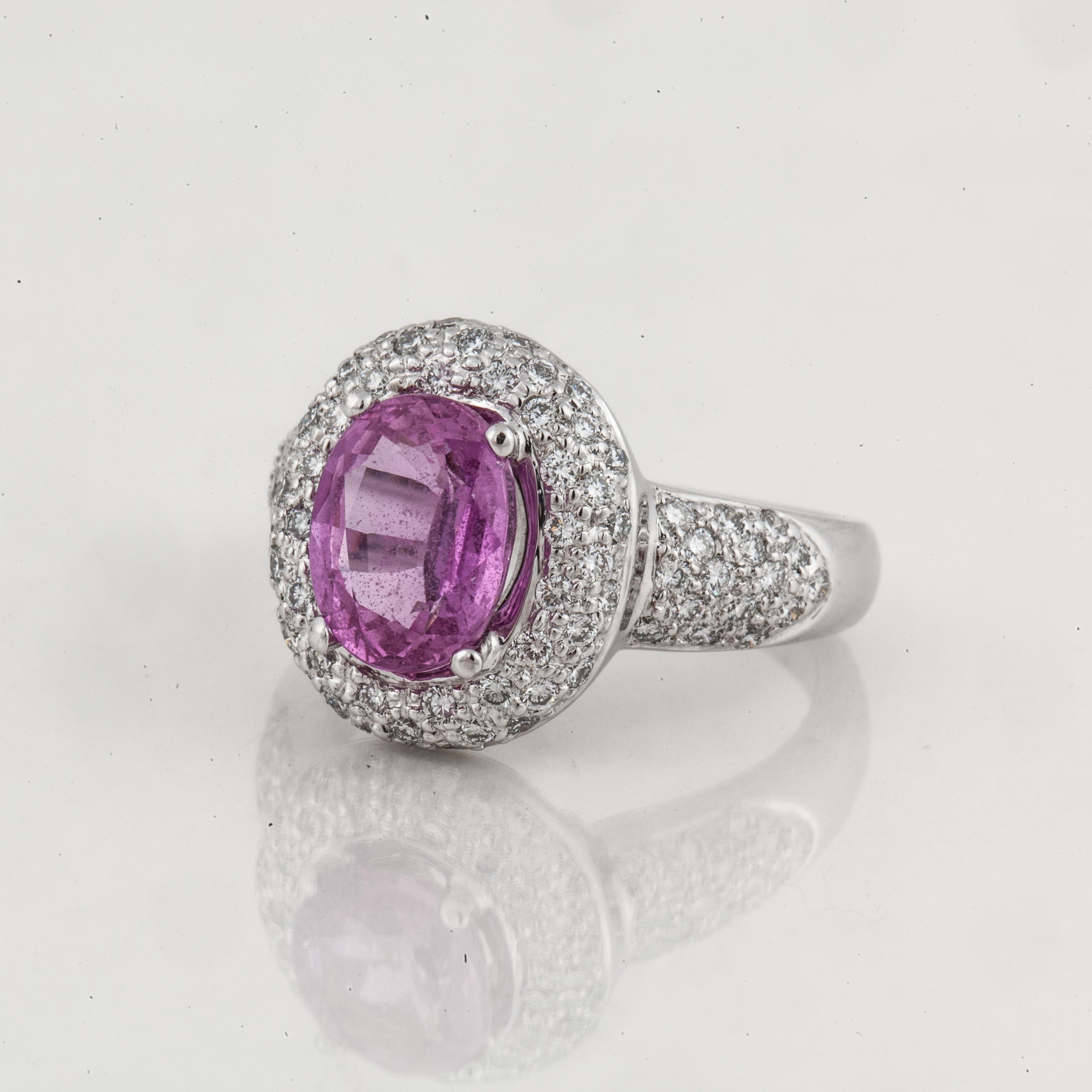 18K white gold ring featuring a 3.03 carat oval shaped pink sapphire surrounded by round diamonds.  There are eighty round diamonds that total 1.20 carats; H-I color and VS clarity.  The presentation area measures 3/4 of an inch by 3/8 of an inch