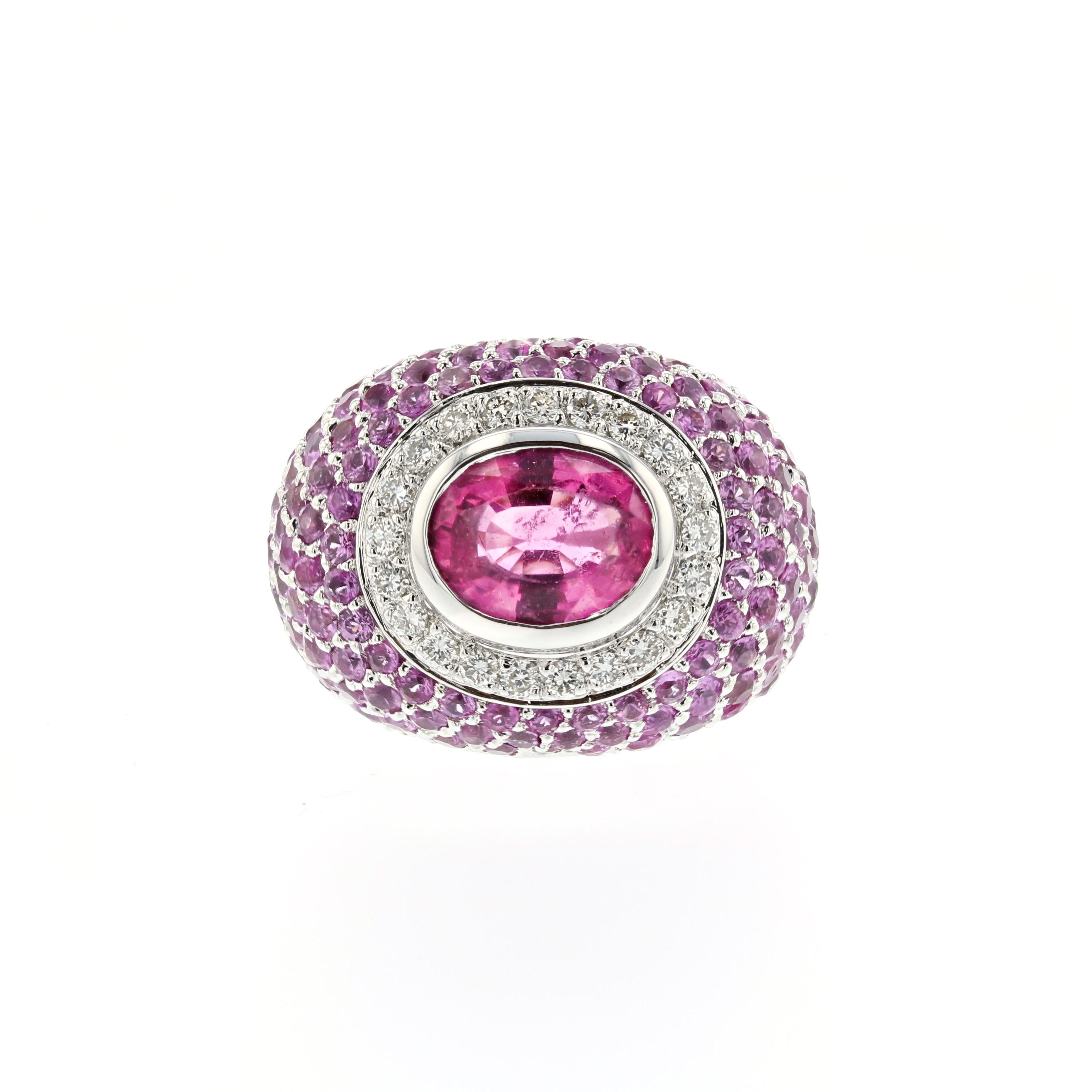 18K white gold ring featuring a 1.55 carat pink tourmaline cabochon with a diamond halo design and round pink tourmalines pavé in a dome design.  Accent pink tourmalines total 3 carats and round brilliant diamonds total 0.40 carats, G color and VS