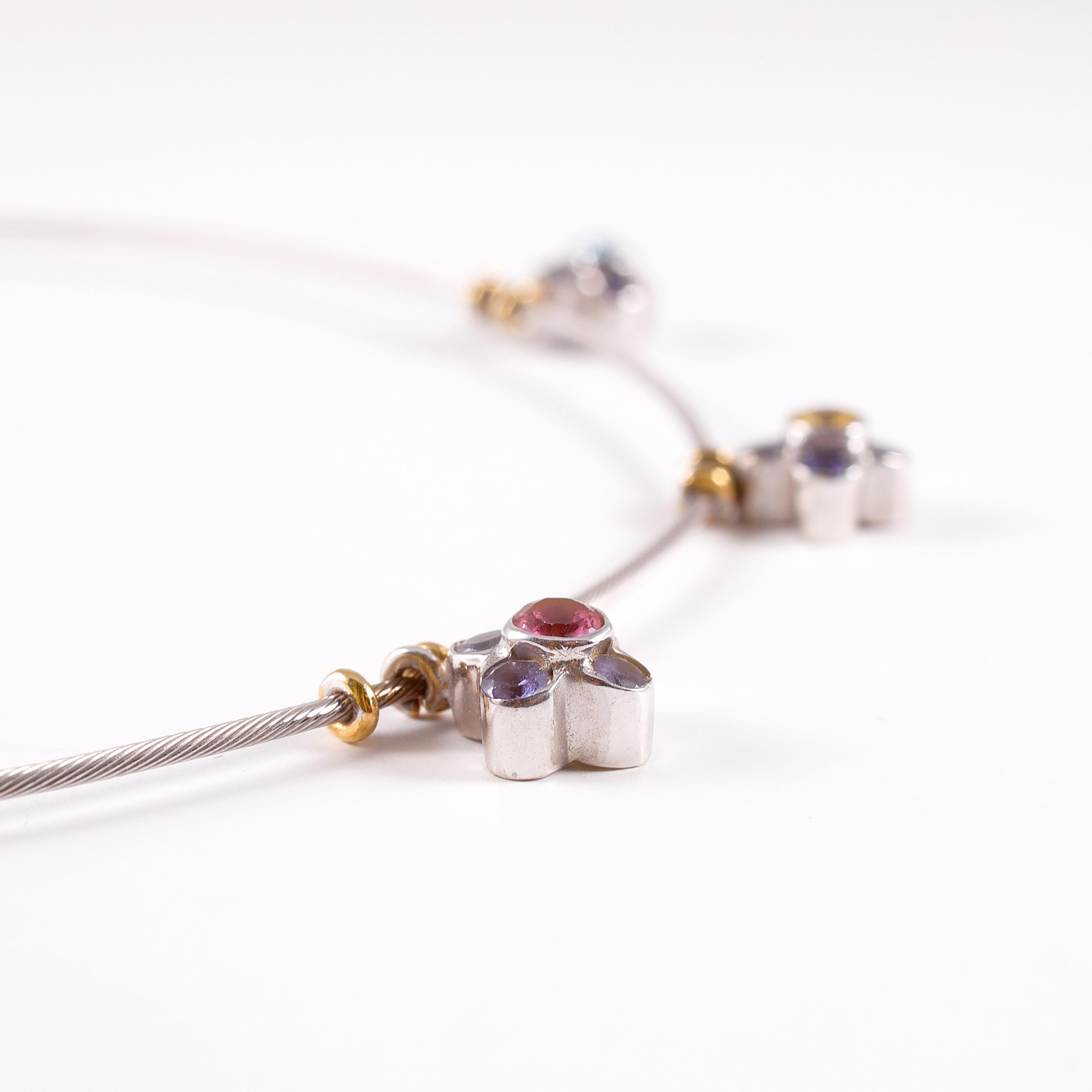 Fun and light!  These three small fixed flowers support one each pink tourmaline, yellow sapphire and blue topaz stones.  