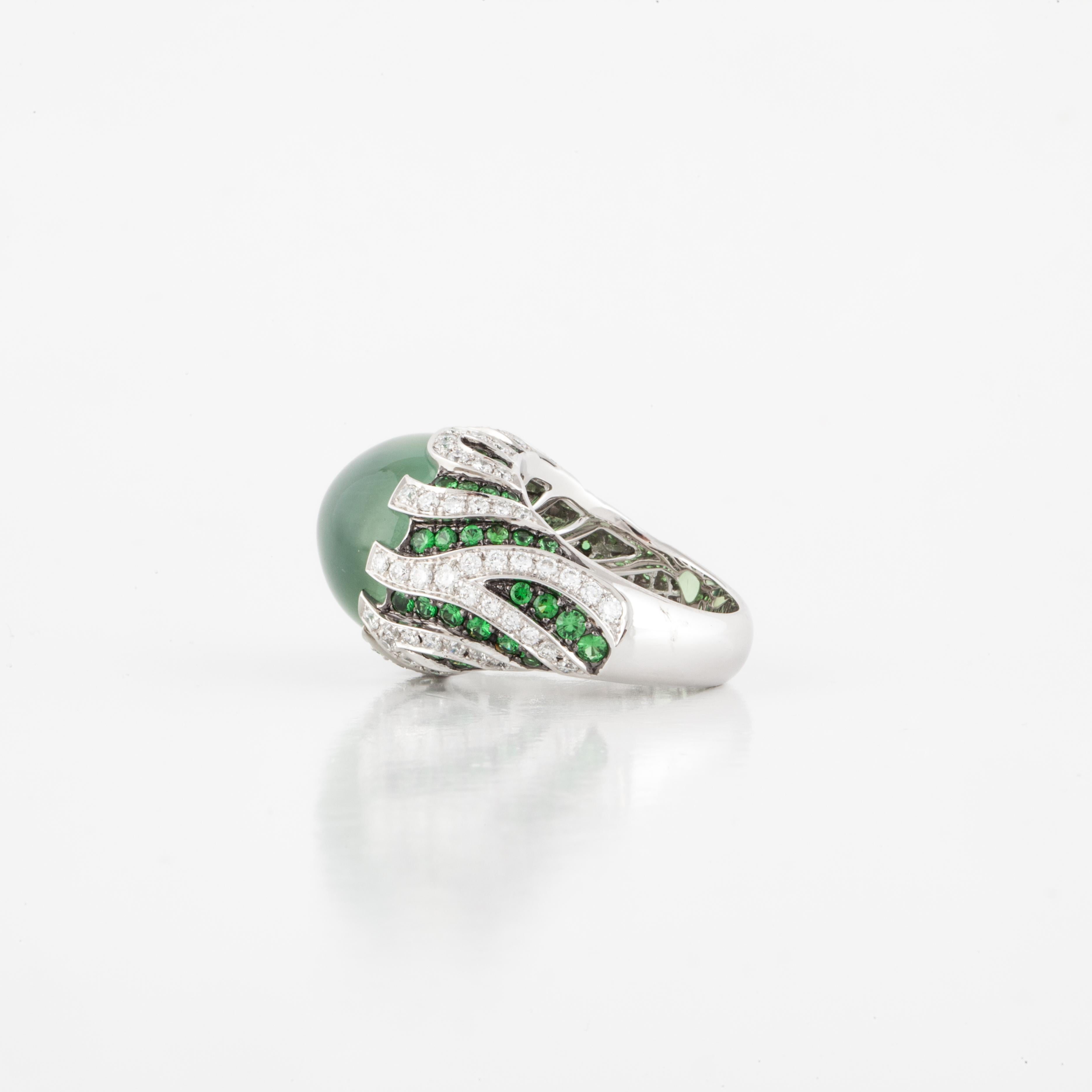 18K white gold domed ring featuring a cabochon prehnite accented by round tsavorite garnets and diamonds.  There are 125 round diamonds that total 3.10 carats; H-I color, VS clarity and 65 round tsavorite garnets.  The ring is currently a size 6 1/2
