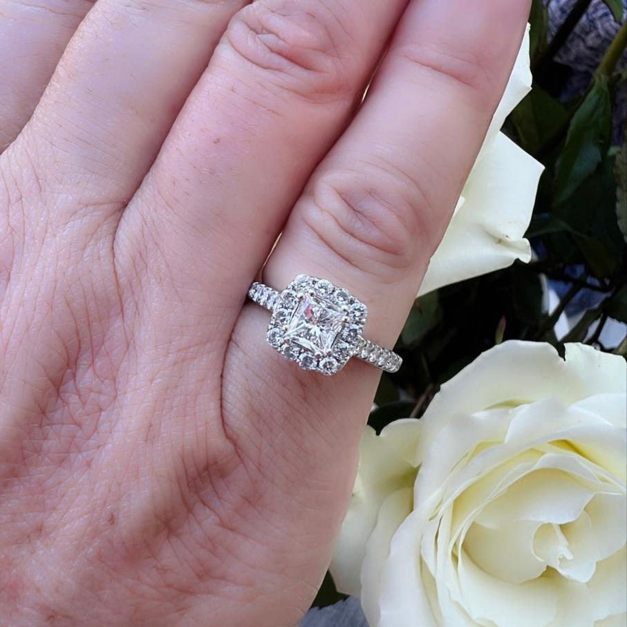 A truly beautiful natural diamond engagement ring at a budget friendly price-point from famed designer Neil Lane. This 14 karat white gold beauty features a .69 carat Princess Cut diamond set in a halo of gorgeous white melee diamonds, with