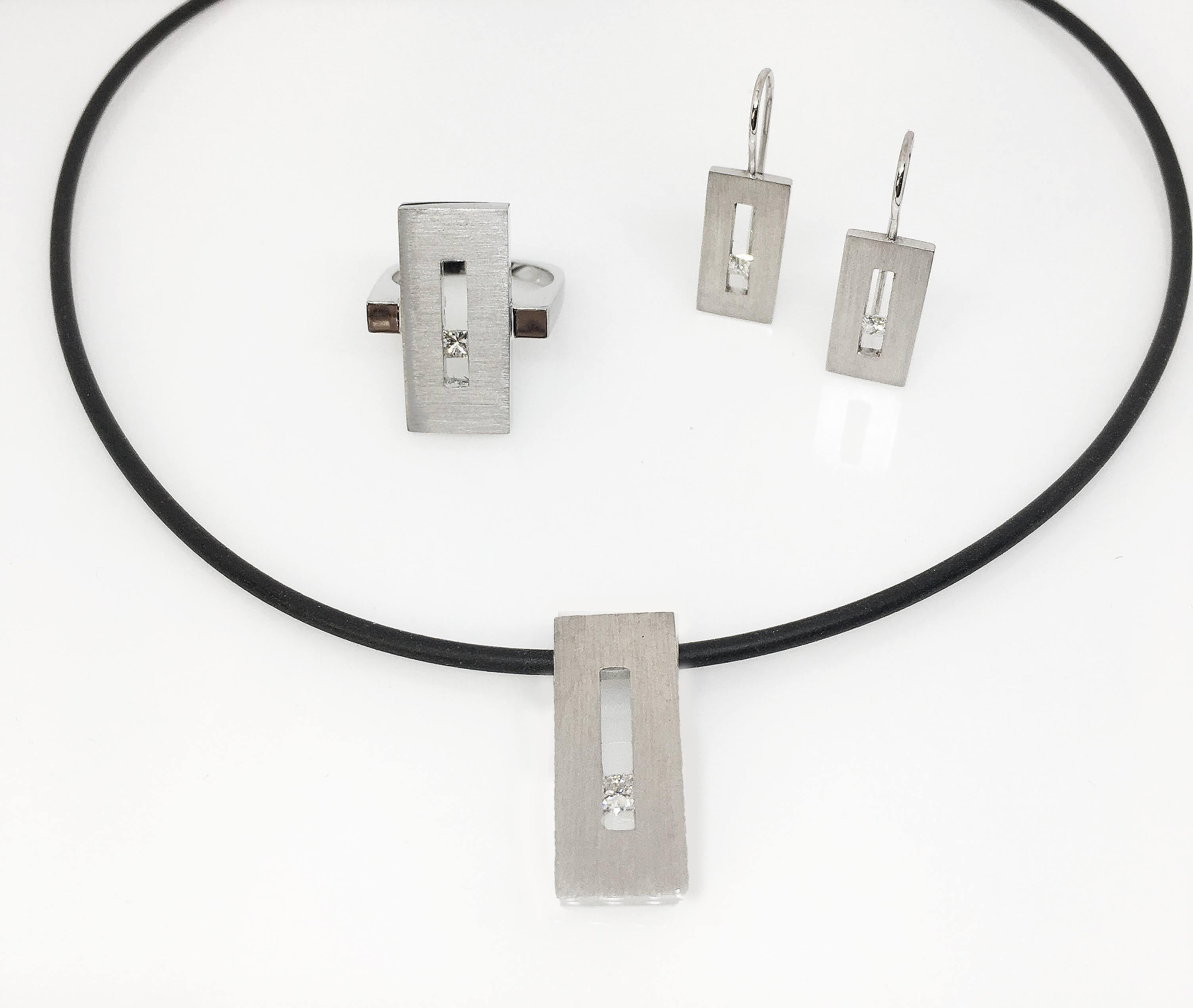 This Princess Diamond in White Gold Rectangle Pendant on Rubber Cord is part of our Suspension Collection. Modern and architecturally inspired, this rectangle pendant is shown in white gold with a brushed finish and set off center with an