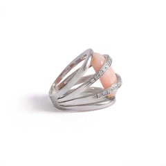 Bague en or blanc sertie de diamants de taille ronde et tenant une pierre dure rose