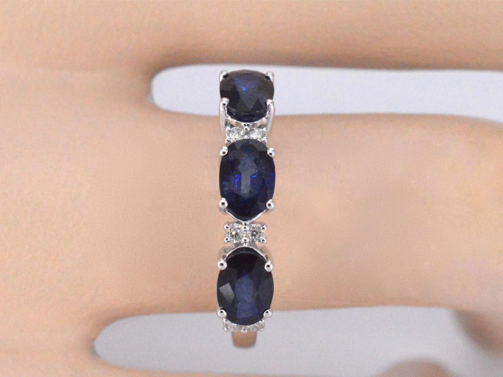 A white gold ring with diamonds and three oval cut sapphires is a striking piece of jewelry that exudes elegance and sophistication. The three oval sapphires are beautifully arranged in a row, each accentuated by diamonds on either side, creating a