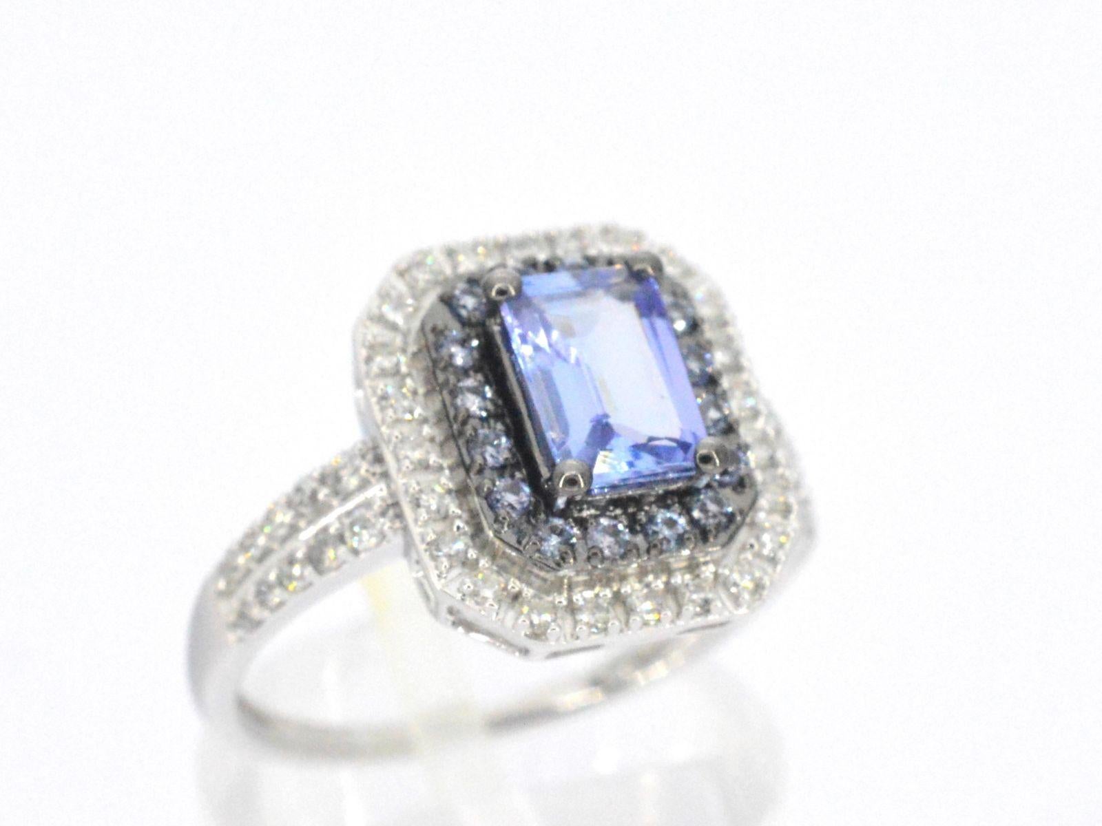 This unique white gold ring is a one-of-a-kind piece of jewelry that features dazzling diamonds and a beautiful tanzanite gemstone. The diamonds are expertly set in the white gold band to create a seamless and elegant look that catches the light