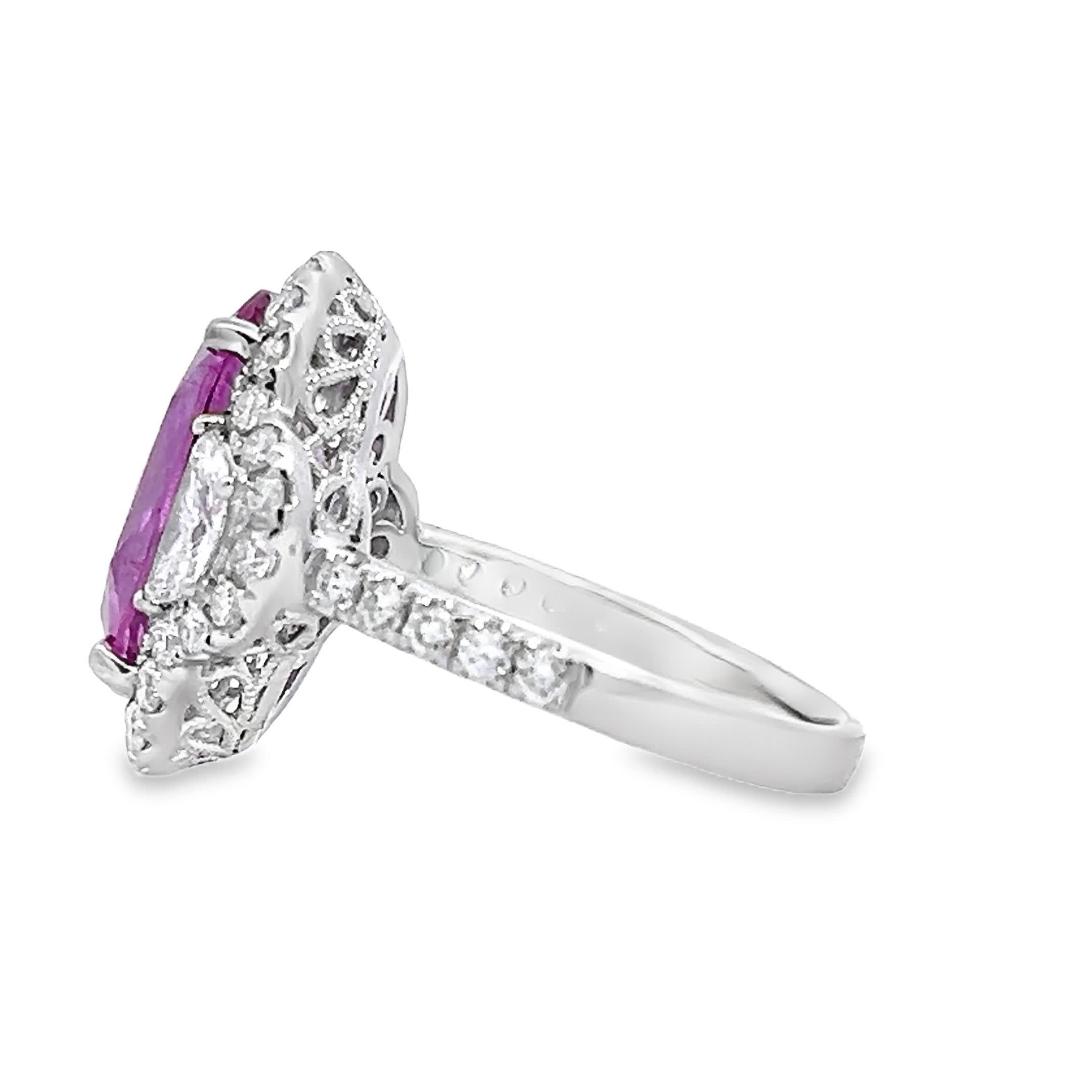 Es handelt sich um einen Ring mit einem zentralen ovalen rosafarbenen Saphir, der einen lebhaften rosafarbenen Farbton mit starker Sättigung aufweist. Der Saphir ist von einem Halo aus runden Diamanten im Brillantschliff umgeben, die die Brillanz