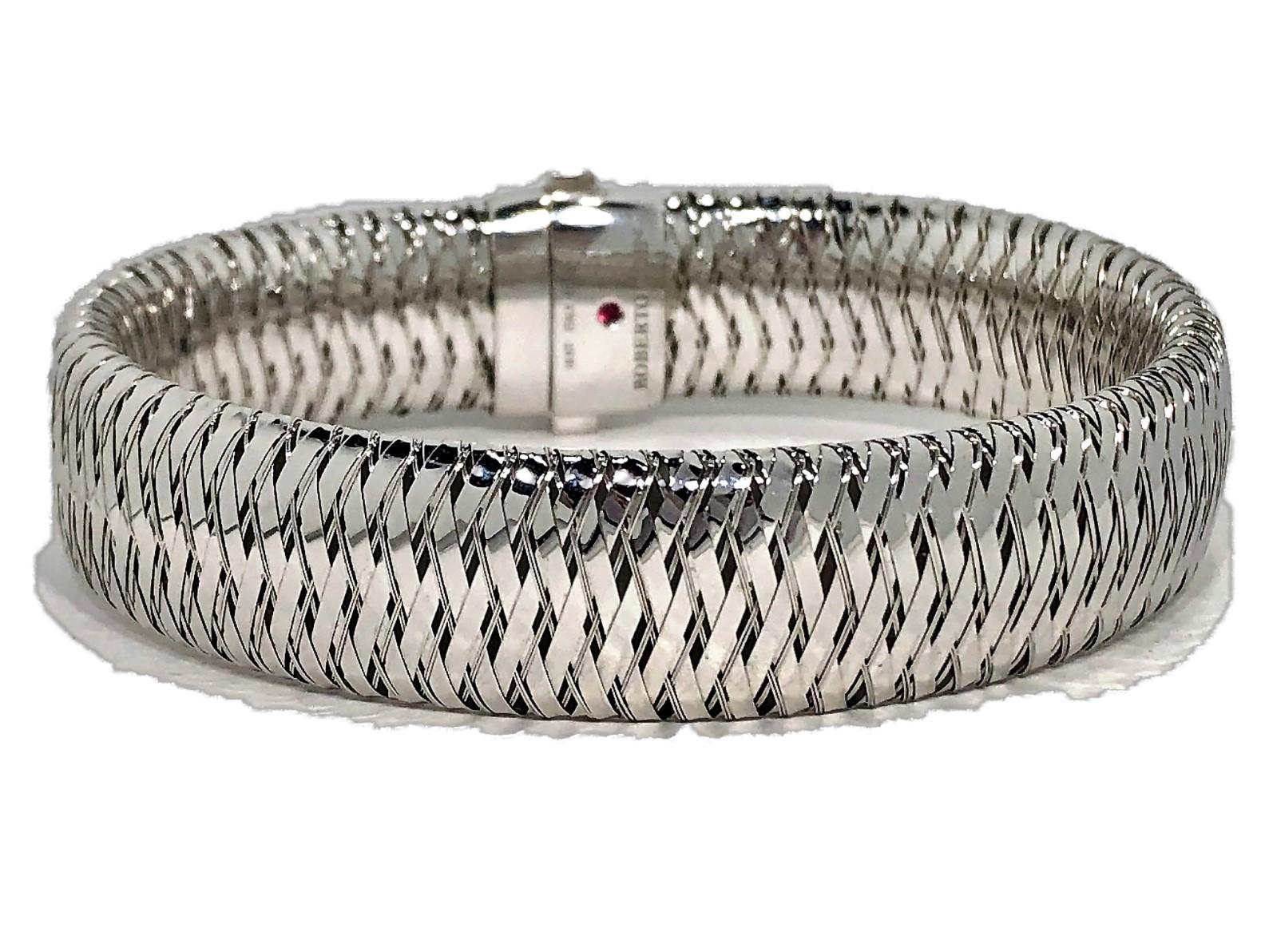 An 18 karat white gold woven design bracelet by Roberto coin,  measuring 
9/16 inch wide by 7 5/8 inches long. Signed Roberto Coin 18 KT ITALY with 
his trademark ruby. by the signature.  Overall weight 27 grams.