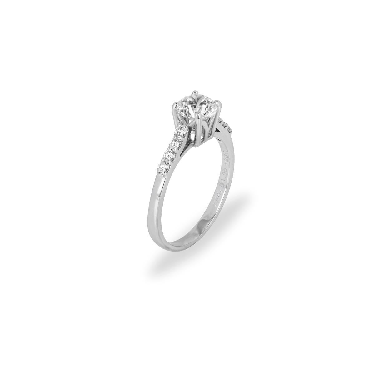 A beautiful 18k white gold diamond engagement ring. The ring is set to the centre with a round brilliant cut diamond in a four claw mount weighing 0.94ct, colour H-I colour and VS clarity. The centre diamond is further complemented with 8 round