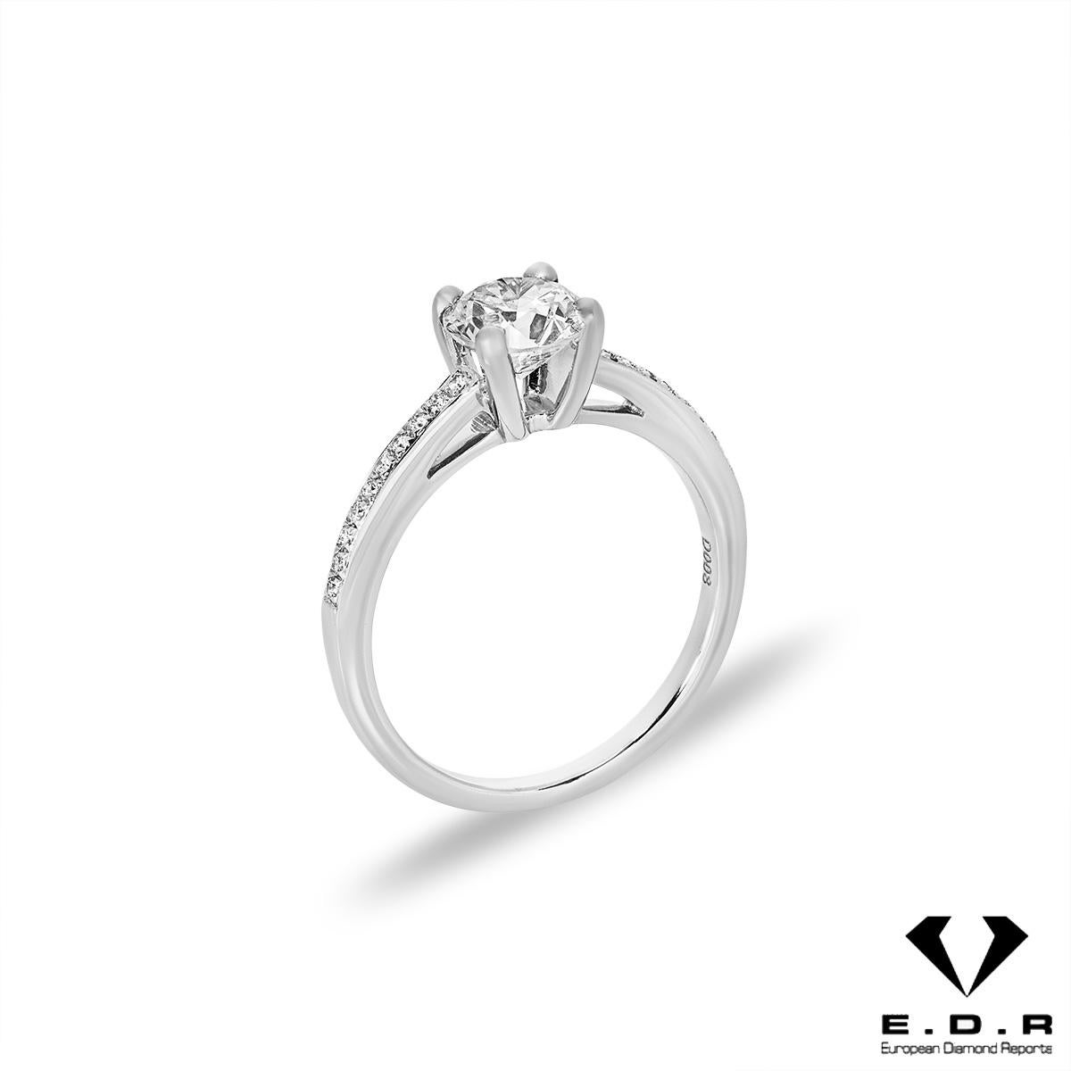A beautiful 18k white gold diamond engagement ring. A round brilliant cut diamond weighing 1.03ct, F colour and VS1 clarity is set to the centre in a four prong mount. Further complementing the centre stone are 20 round brilliant cut diamonds pave