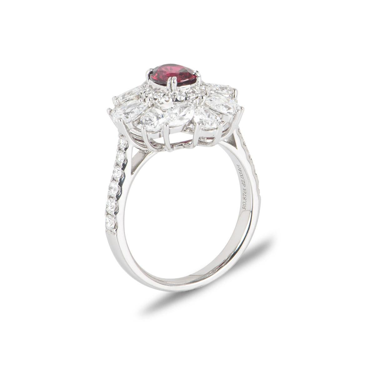 A gorgeous ruby and diamond dress ring. The ring is set to the centre with an oval cut ruby weighing 0.87ct displaying a deep red hue. The ruby is surrounded by a small halo of 16 round brilliant cut diamonds that are further complemented by