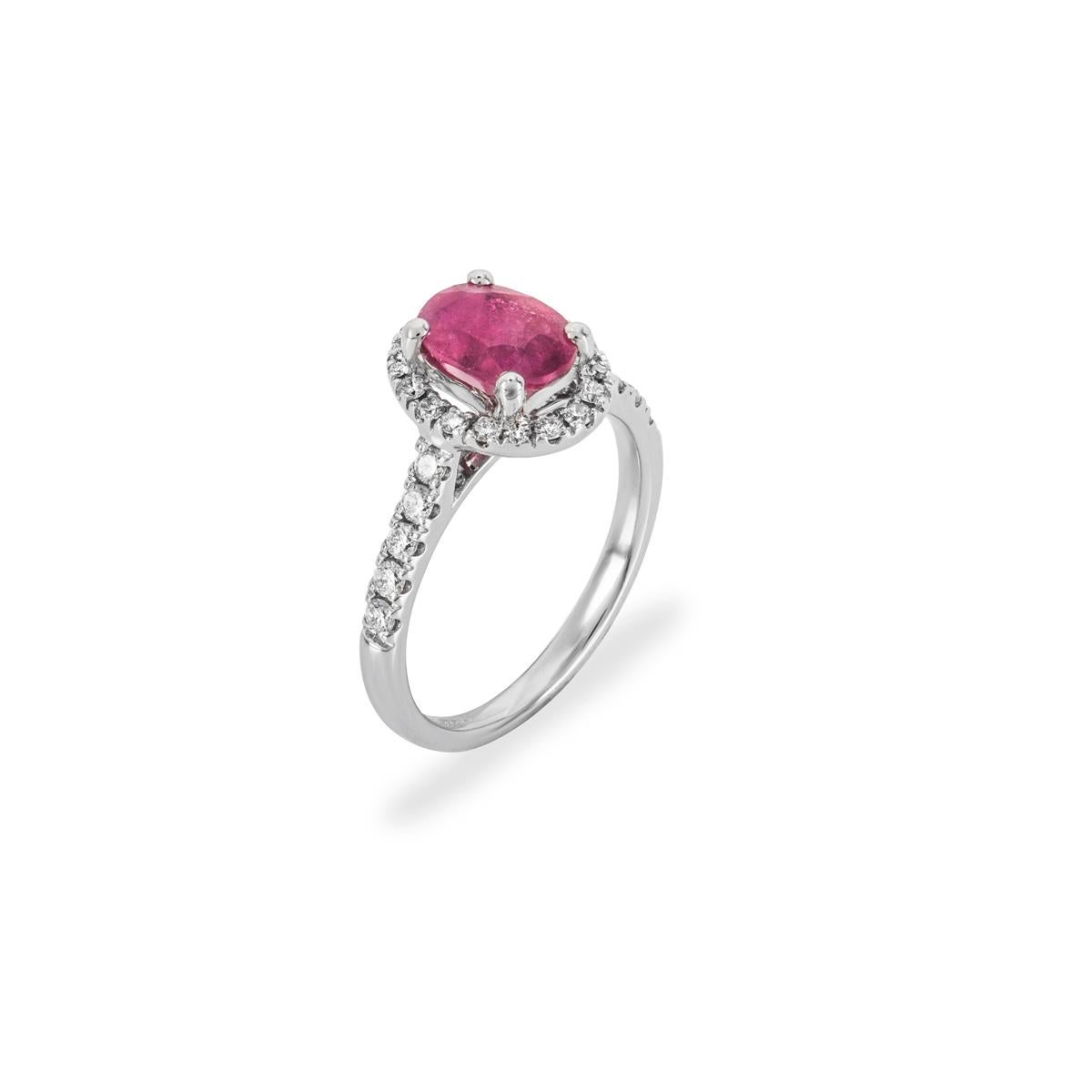 Ein wunderschöner Halo-Ring aus 18 Karat Weißgold mit Rubinen und Diamanten. Der Ring ist in der Mitte mit einem oval geschliffenen Rubin mit einem Gewicht von ca. 1,28 ct besetzt, der einen milchig roten Farbton aufweist. Ergänzt wird der Rubin