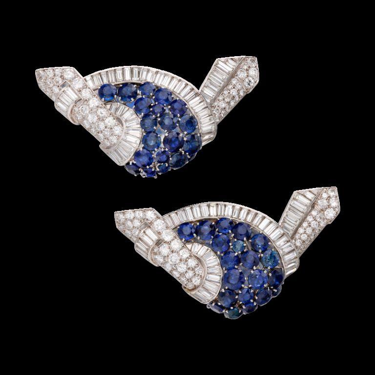 A pair of matching clip brooches, each featuring 94 round diamonds and 20 round sapphires. 
- Diamonds weighing a total of approximately 15.90 carats 
- Sapphires weighing a total of approximately 34 carats
 - 18 karat white gold
 - Total weight