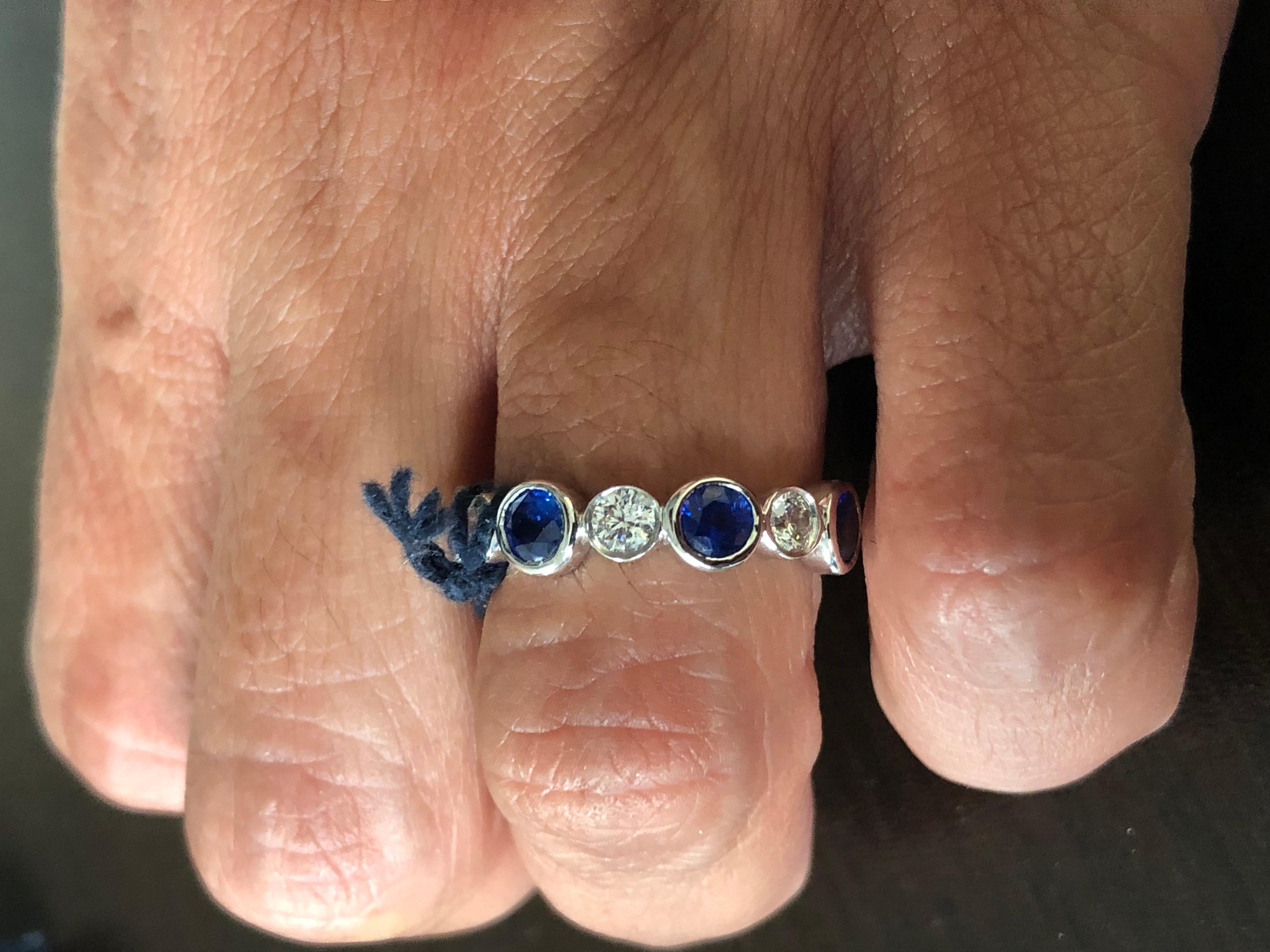 Sapphire and Diamond alternating eternity ring set in a bezel. The ring is 14K white gold. The total weight of the sapphires is 2.10 carats. The weight of the diamonds is 0.84 carats. The sapphires are Ceylon. Diamond color and clarity is G,