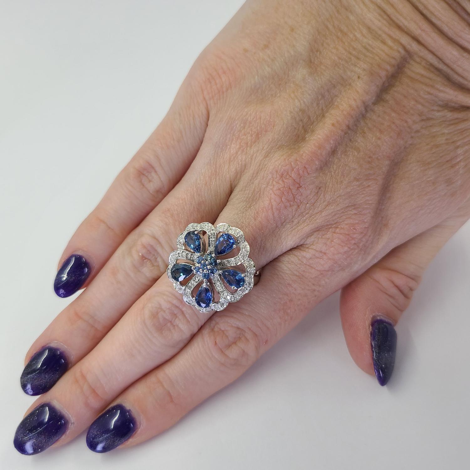 Elegant 14 Karat White Gold Flower Ring with 3 Dimensional Openwork Design. Featuring 5 Pear Cut Sapphires and 7 Round Sapphires Totaling Approximately 2.00 Carats Accented By 40 Single Cut Diamonds of SI Clarity and H/I Color Totaling 0.20 Carats.